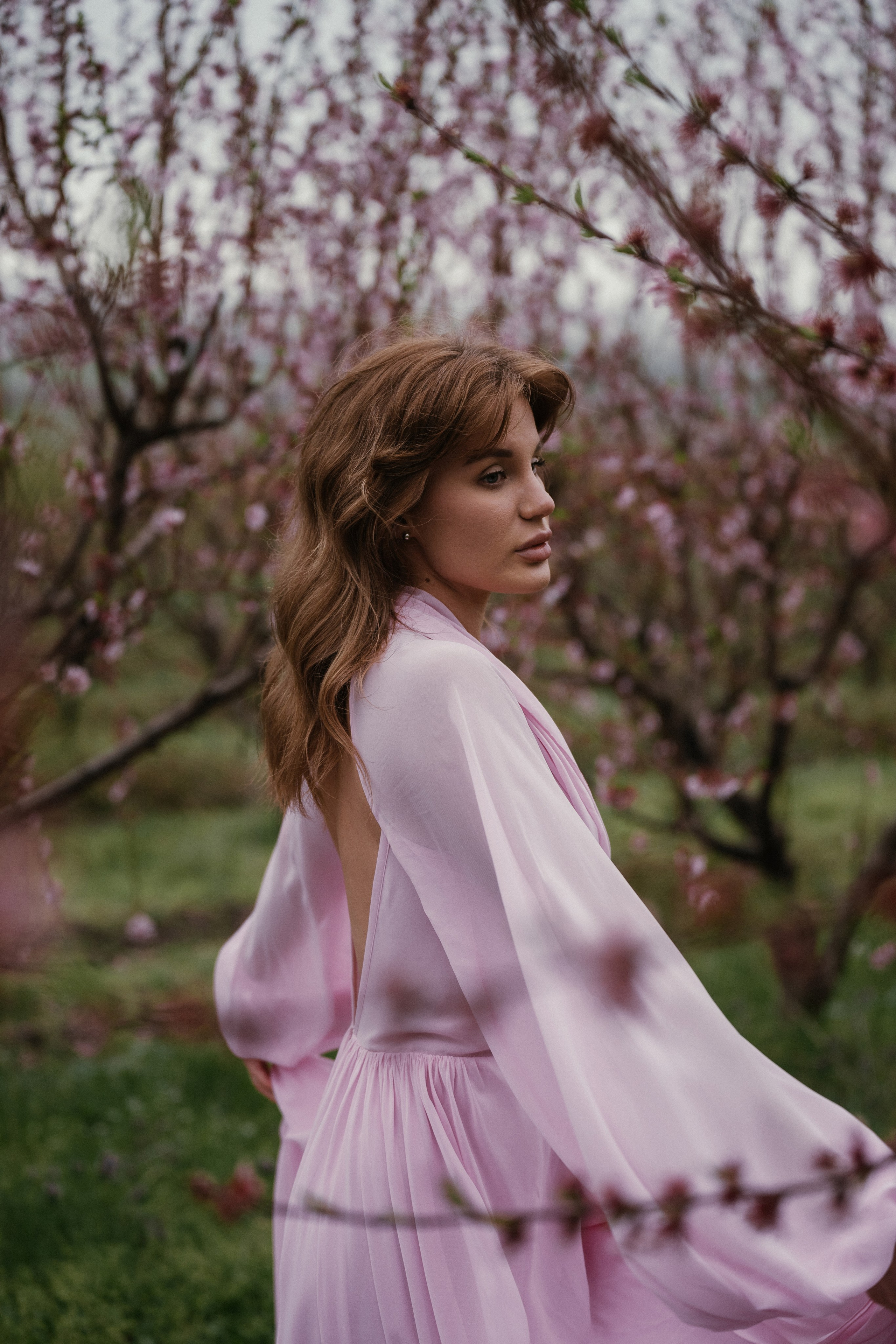 Фотосессия в стиле сказки: развевающееся розовое платье в цветущем саду