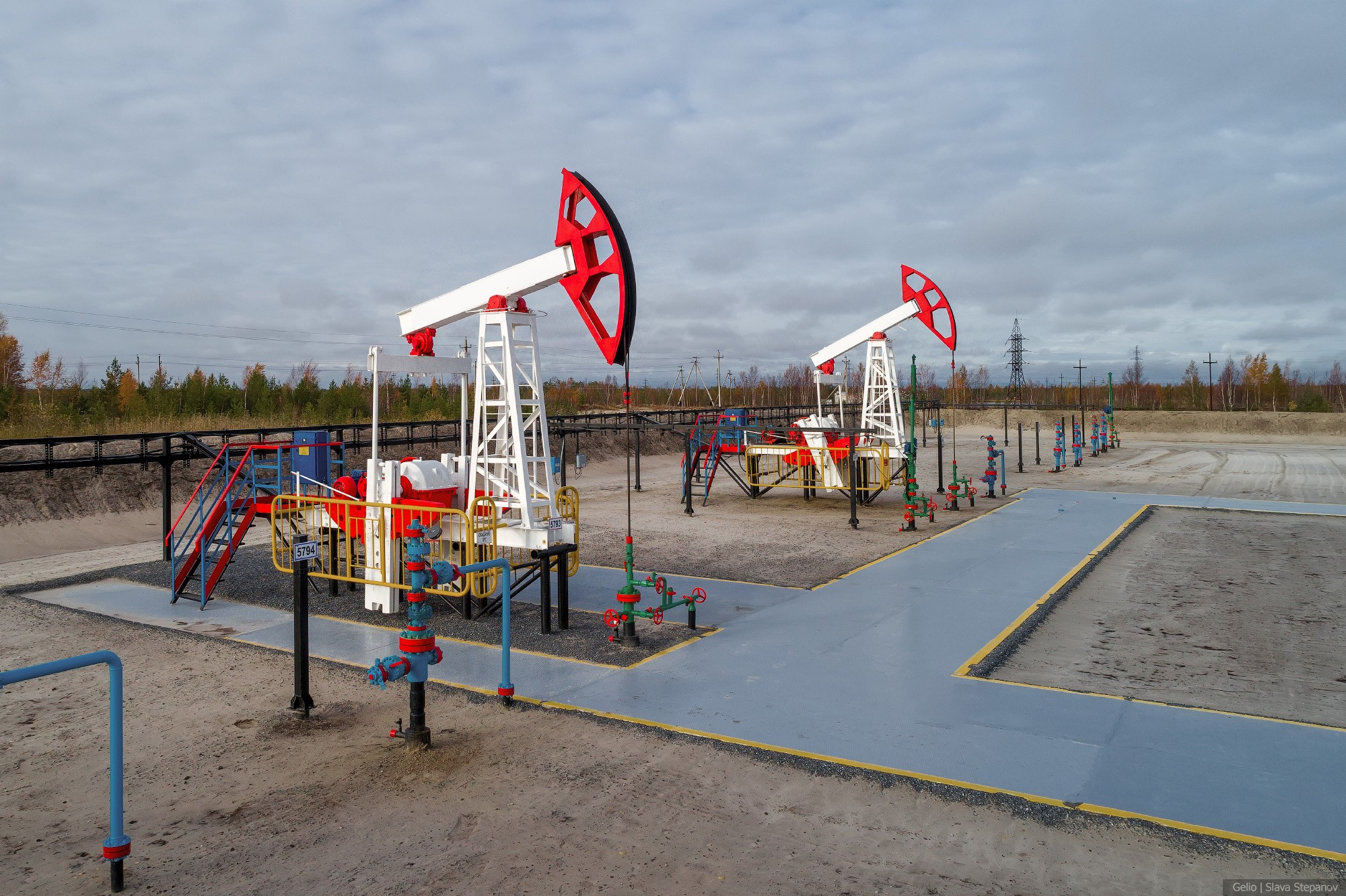 Ритм нефтедобычи: работающие станки-качалки на фоне осеннего пейзажа, подчеркивающие масштаб освоения месторождения.
