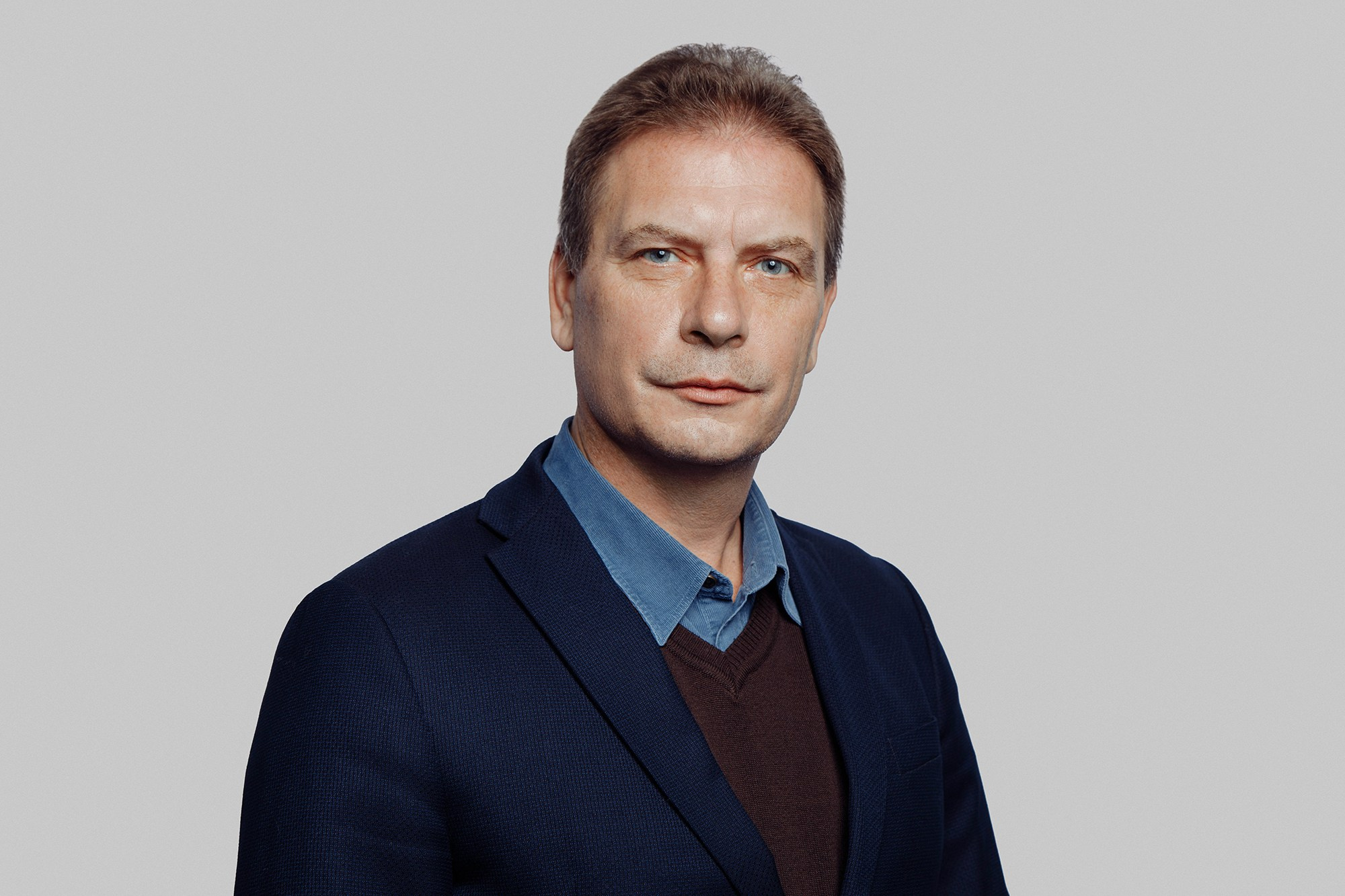 Классический деловой портрет мужчины на светлом однотонном фоне.