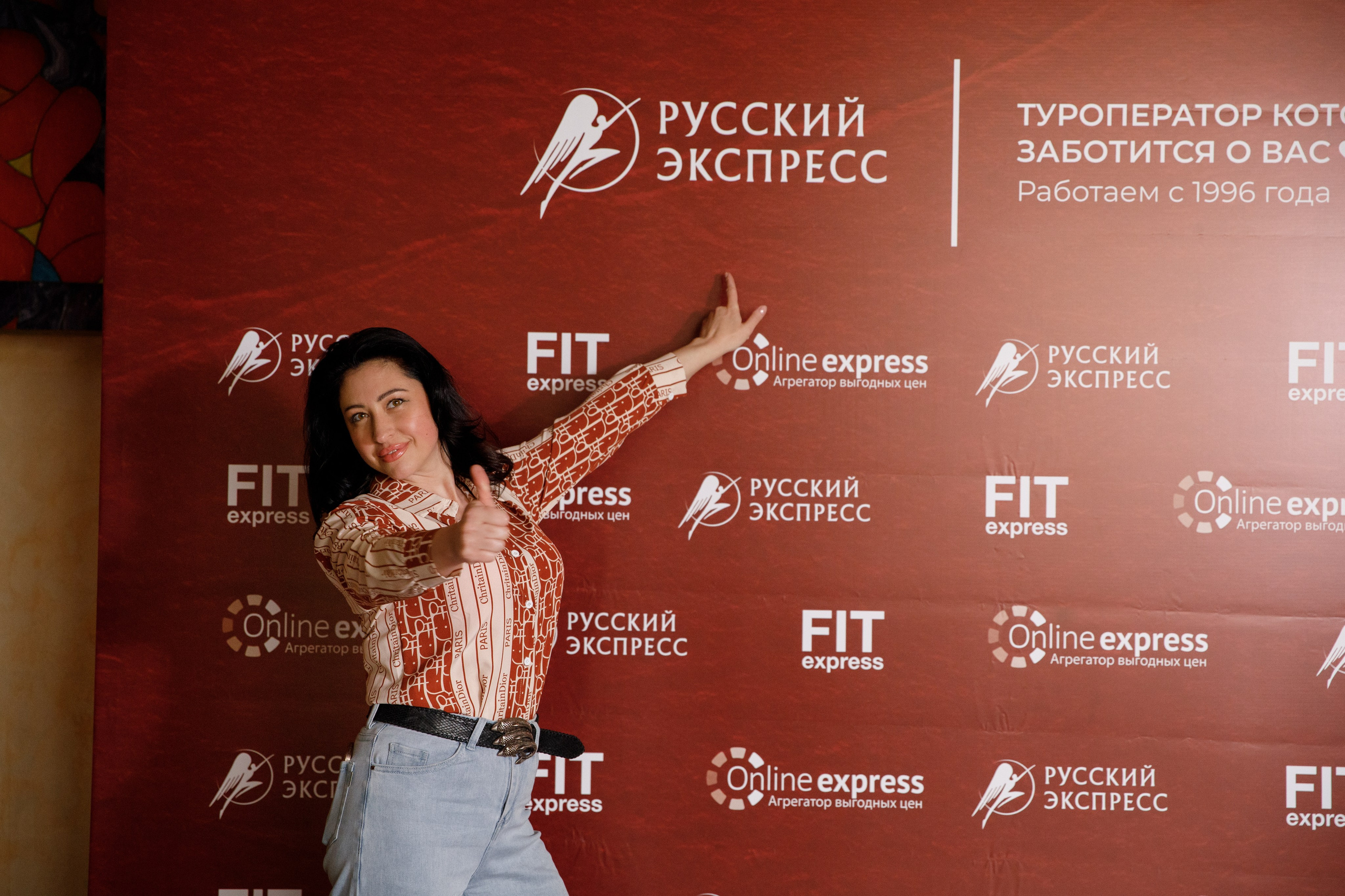 Гостья туристического мероприятия на брендированной фотозоне компании «Русский Экспресс»