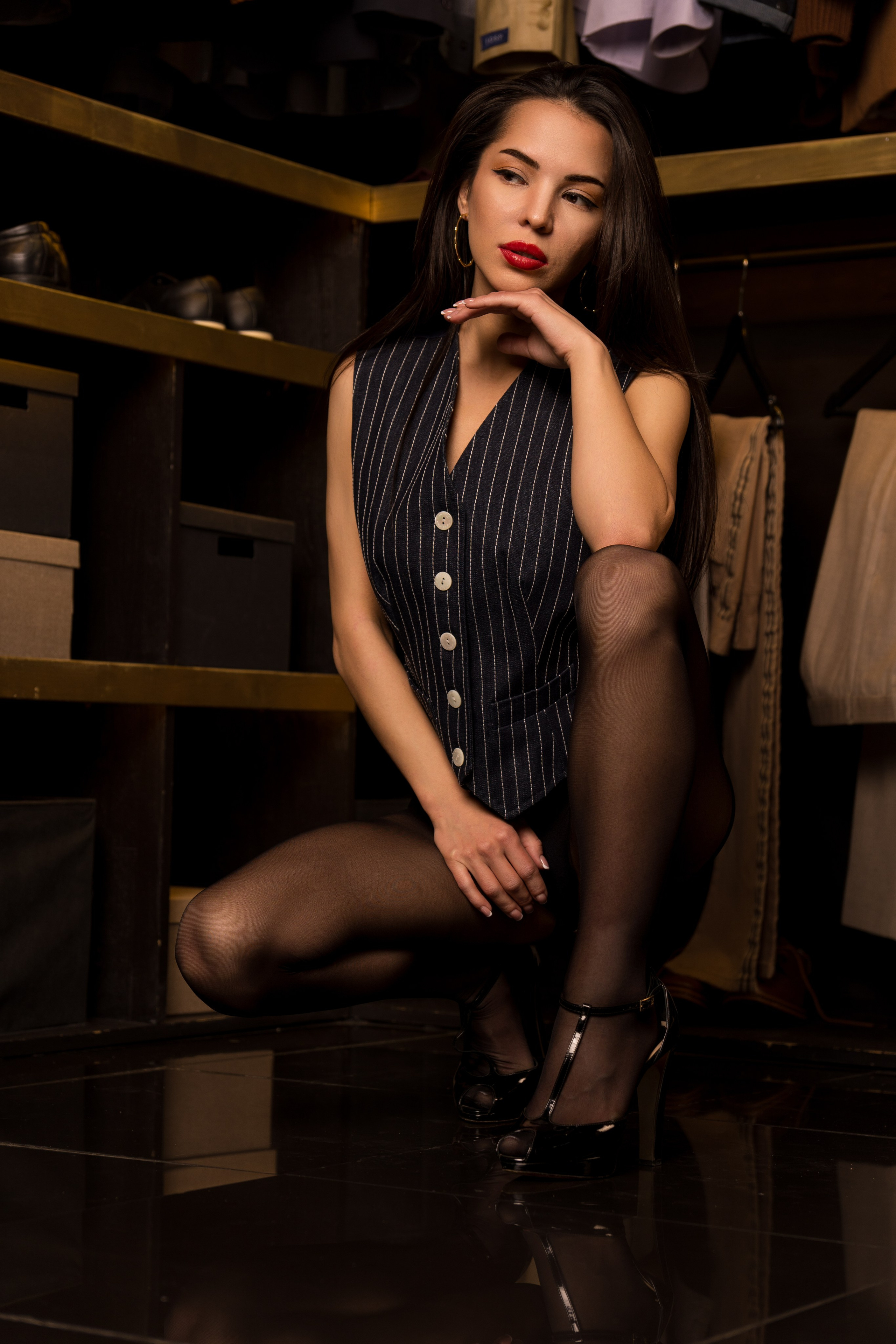 портрет девушки в колготках и пиджаке, которая сидит в гардеробной