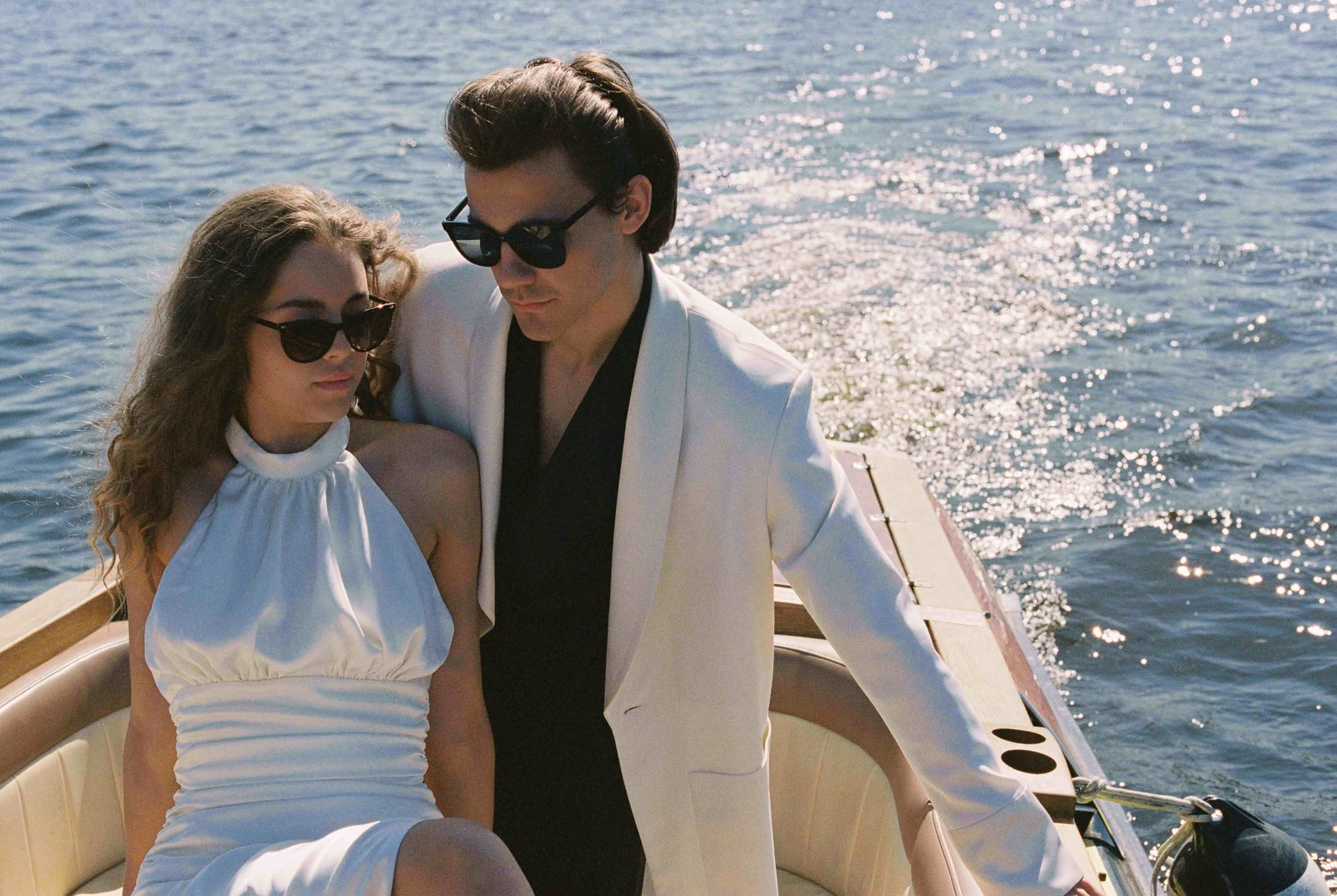 Фотосессия на плёнку Санкт-Петербург — стильная пара на моторной лодке, солнечные блики на воде