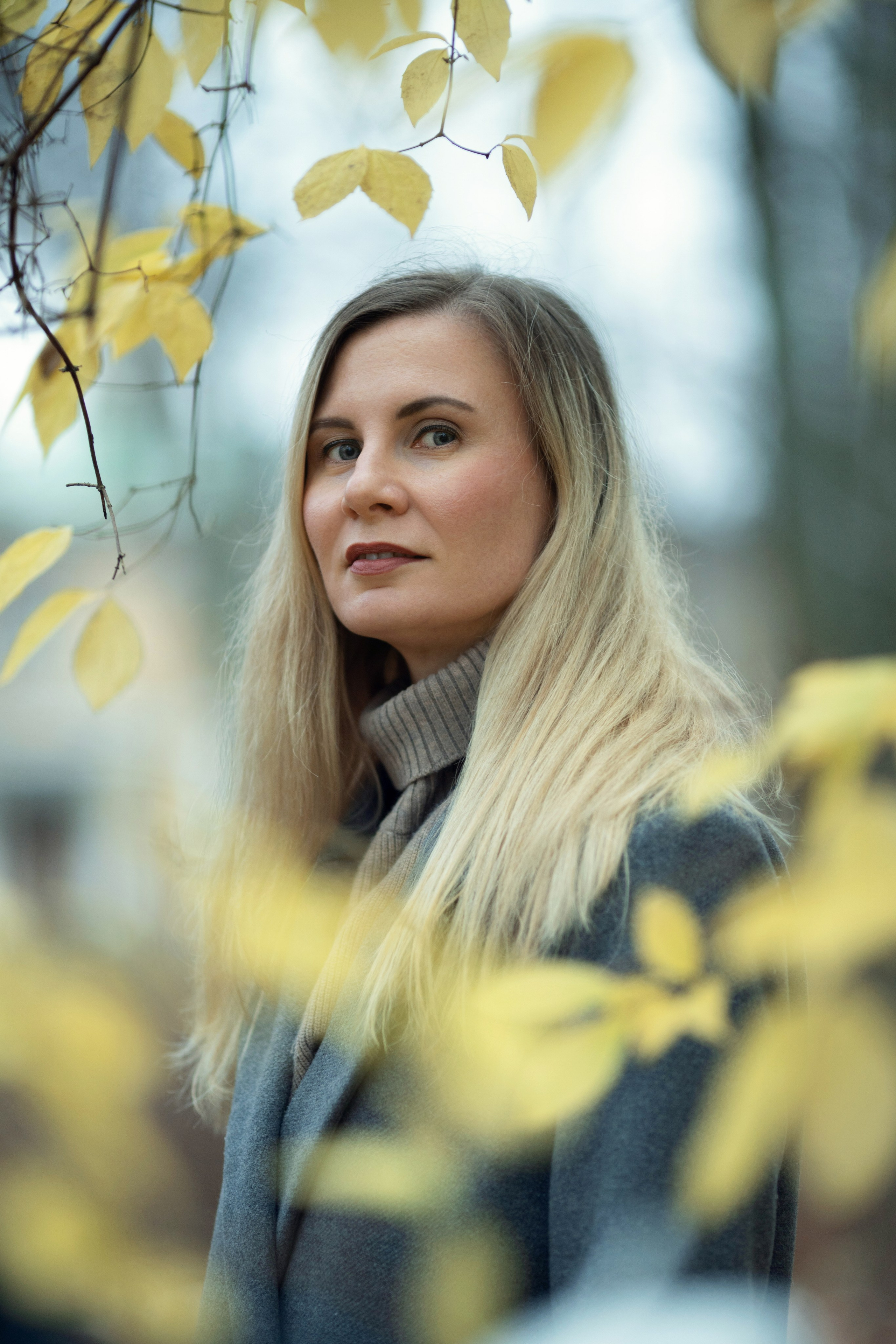 Женщина в осеннем парке прогуливается.