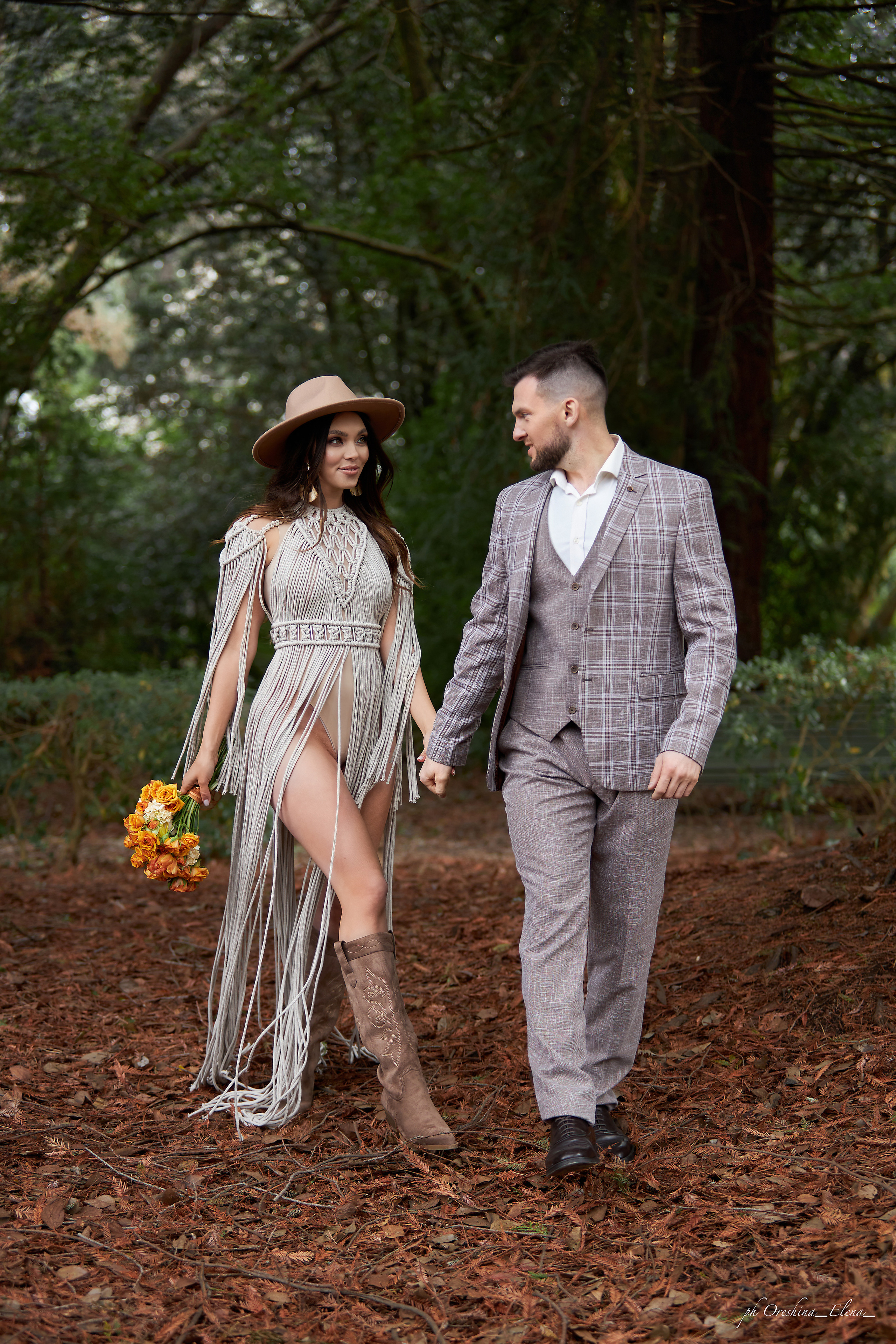 Невеста смотрит на жениха, прогуливаясь по парку