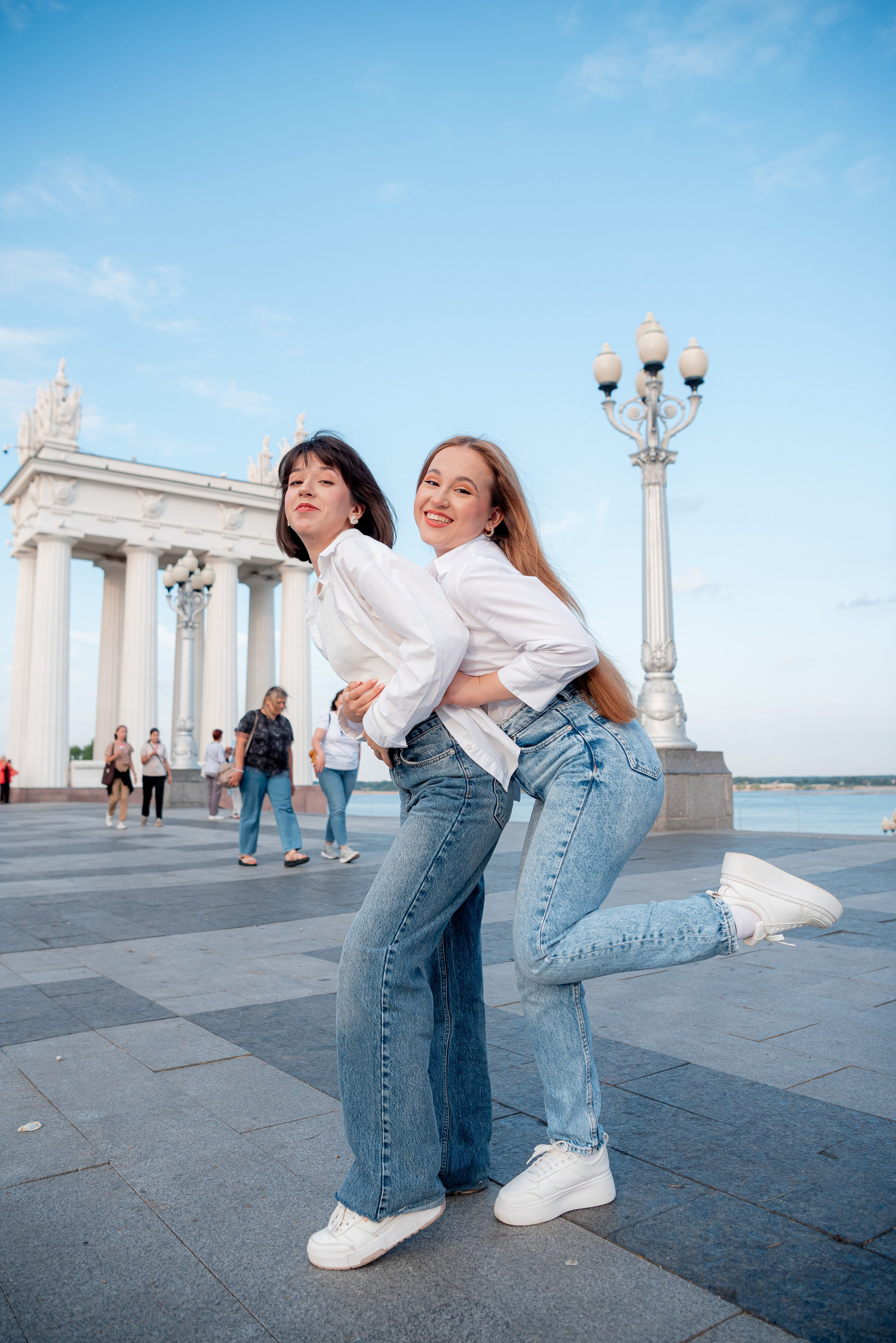 Взрослые сестры играют друг с другом на набережной Волгограда около ротонды