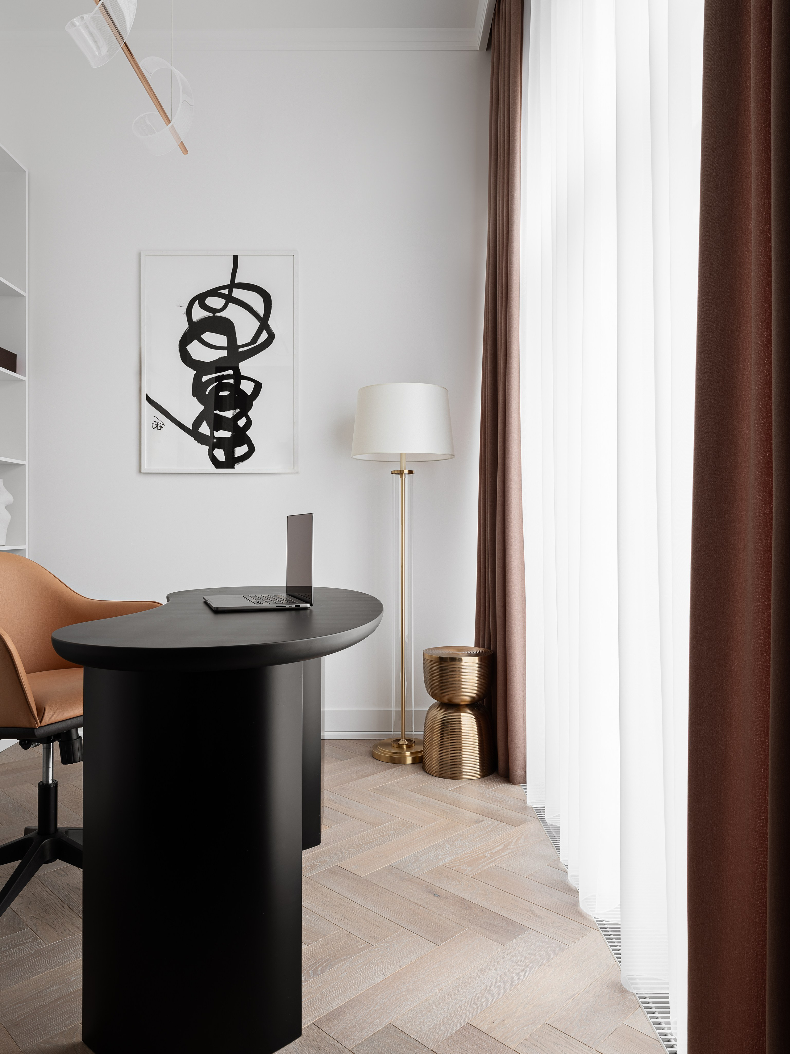 Светлый кабинет с панорамными шторами: чёрный стол необычной формы, акцентное настенное панно в графичном стиле, торшер с белым абажуром и латунным основанием. Интерьер оформлен дизайнером Василиссой Бачевой, стилист Наталья Якушева, фото Сергей Денисенко.
