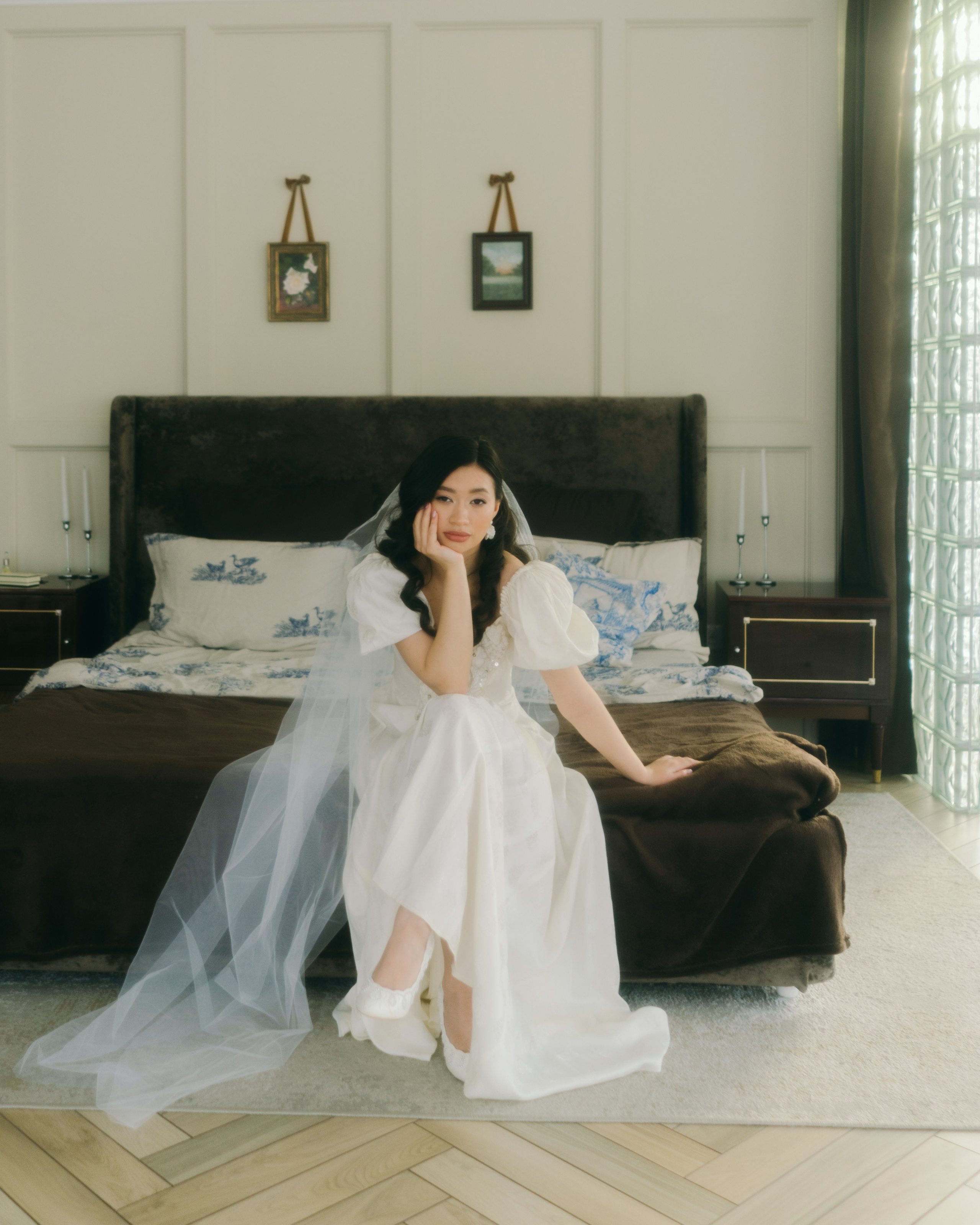 Невеста сидит на кровати в фате, утро невесты фотосессия в светлой студии, романтичный свадебный кадр
