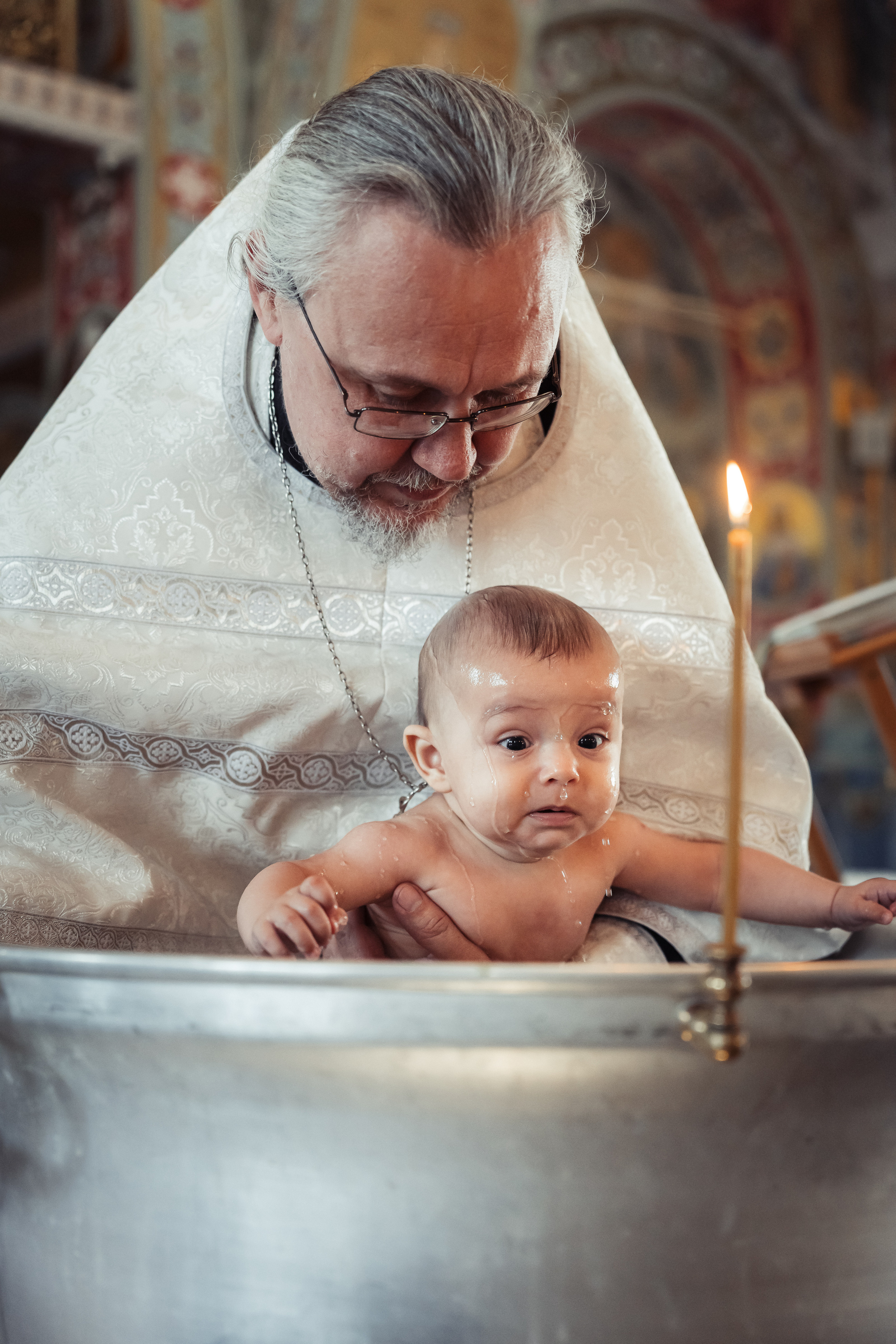 Окунание в купель при крещении малыша