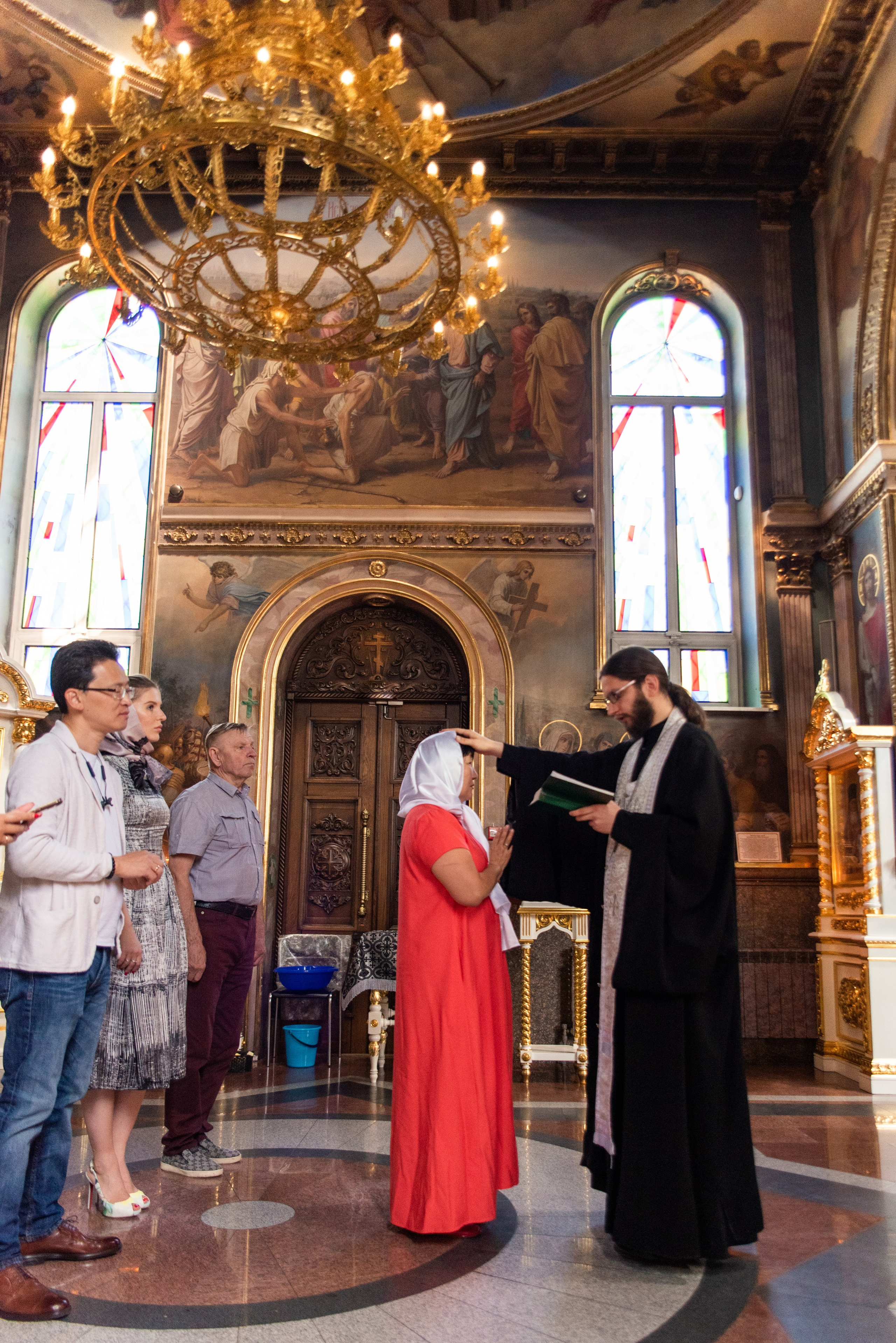 Священник возлагает руку на крещаемого и произносит слова молитвы - фотосъемка крещения взрослого в Краснодаре
