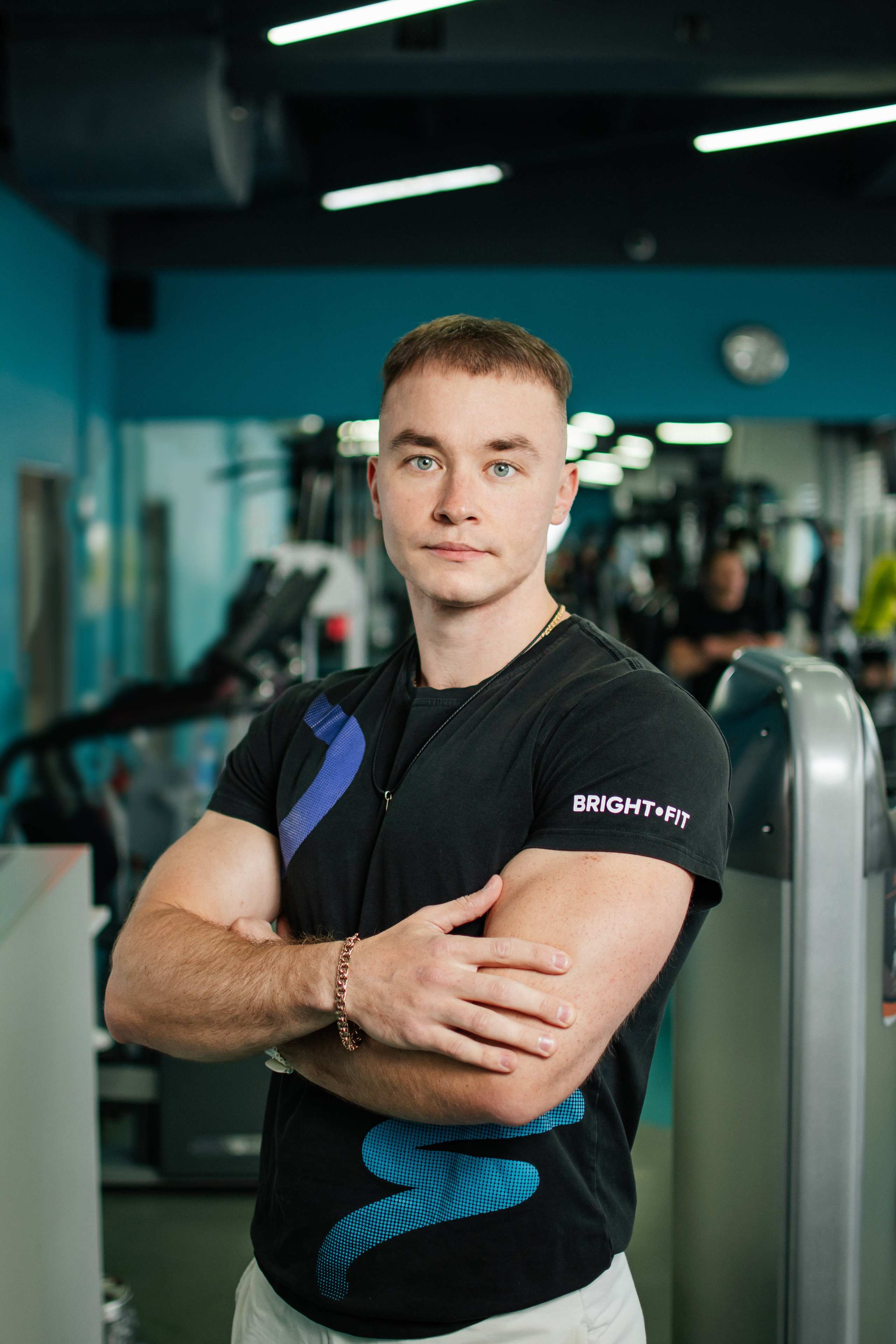 тренер фитнес-клуба на фоне зала фитнес-клуба