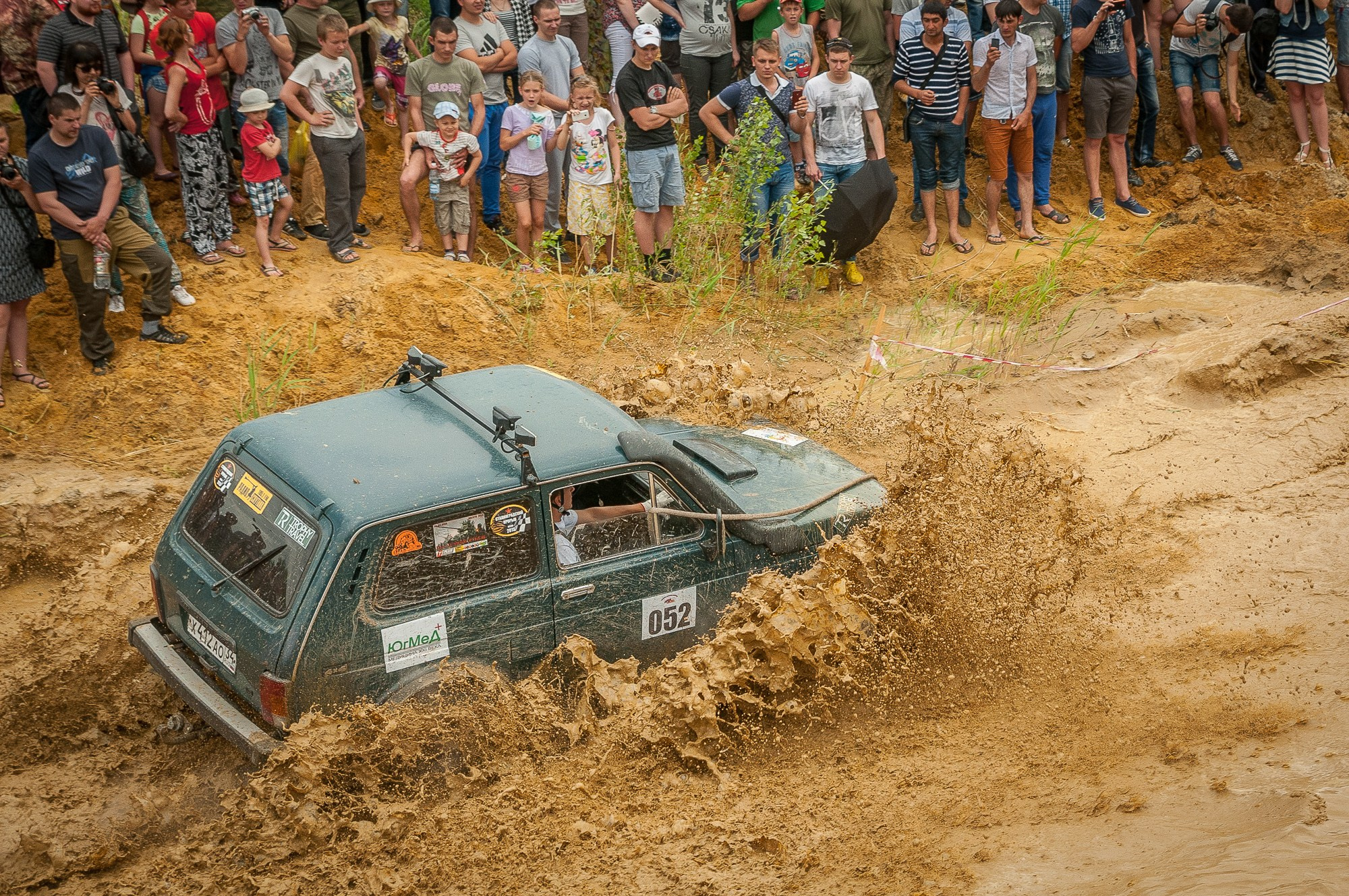 Нива преодолевает водоём среди наблюдающих зрителей по краям берегов