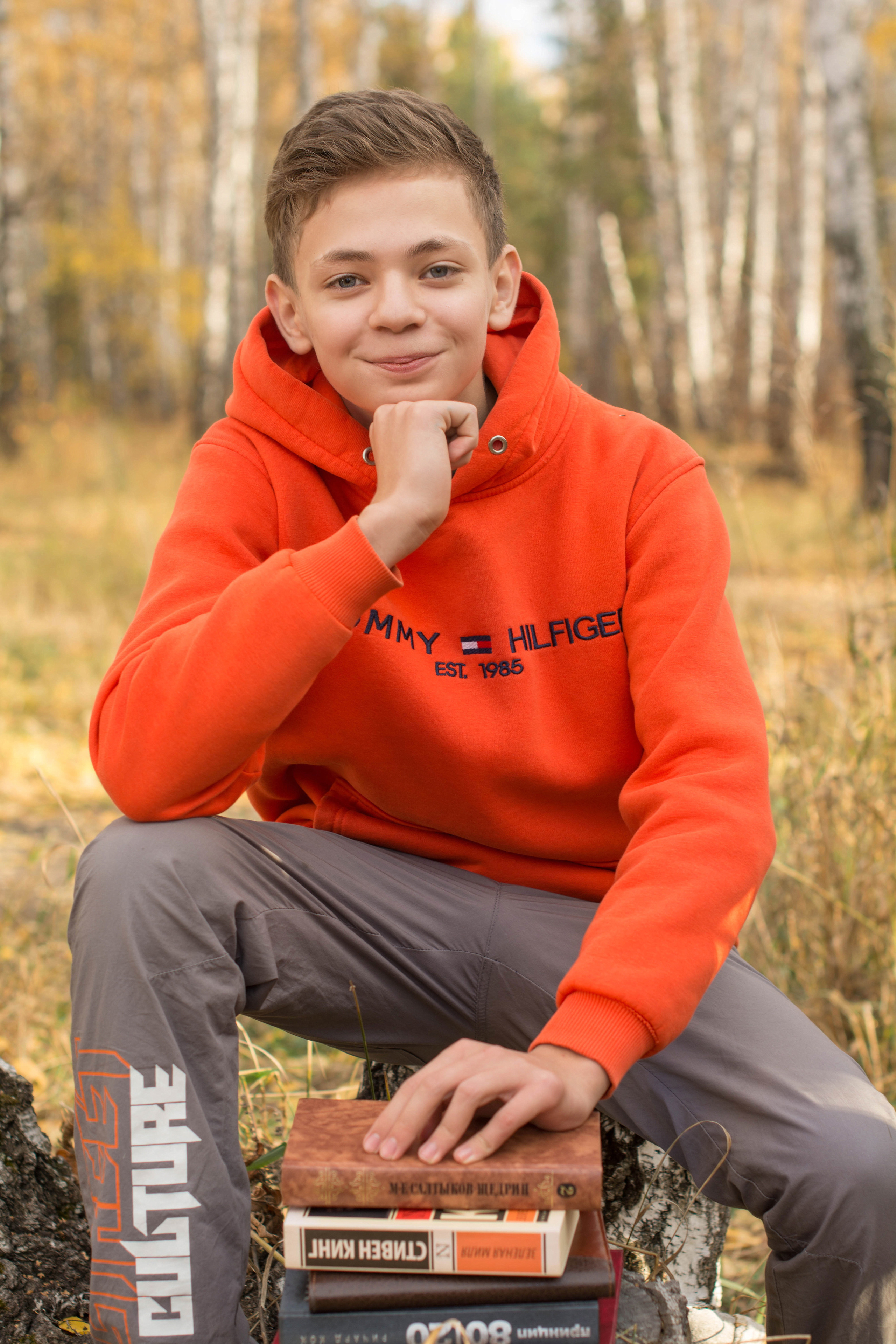 Портретное фото парень в оранжевой кофте.