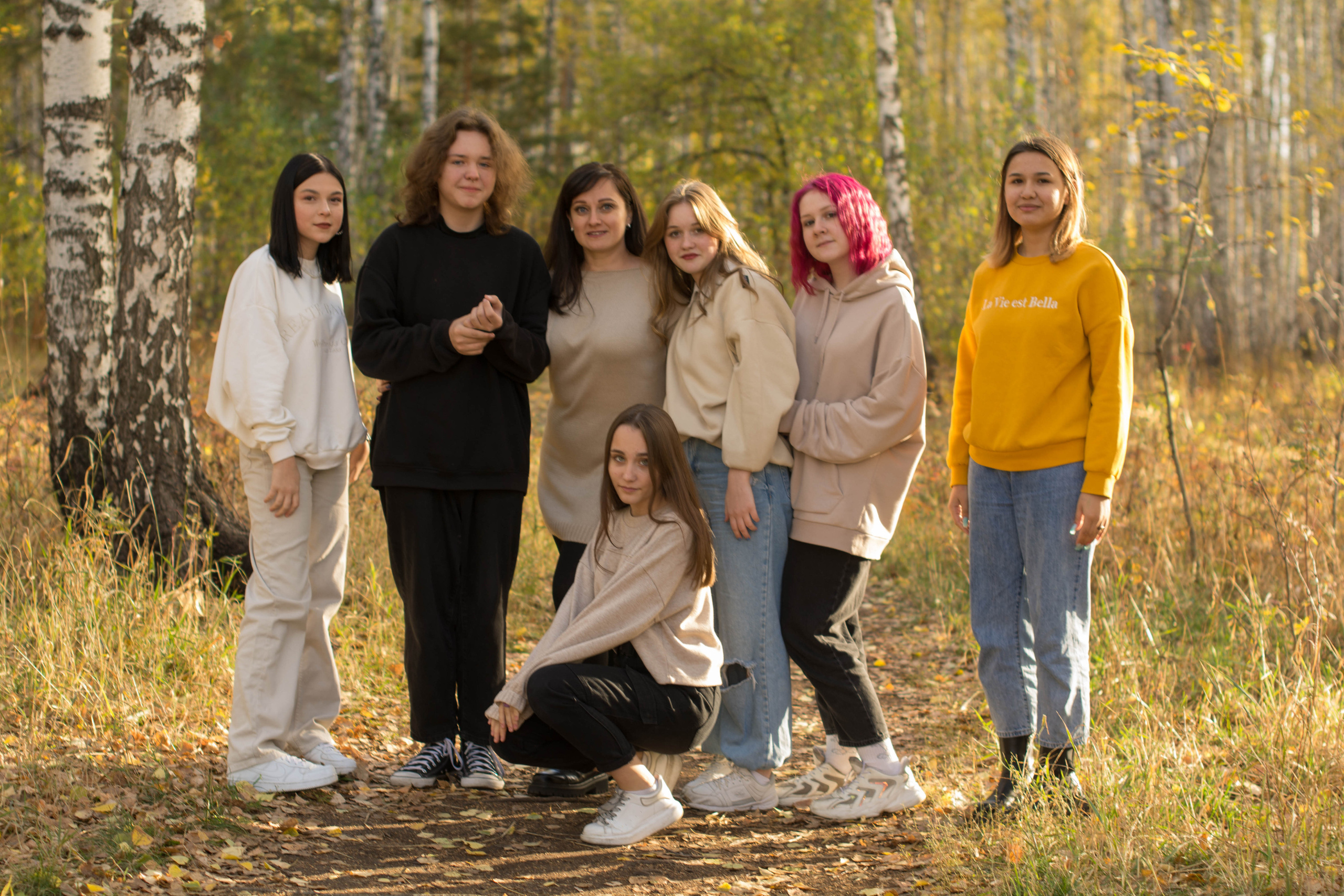 Девочки красавицы позирует на камеру осенью на улице.