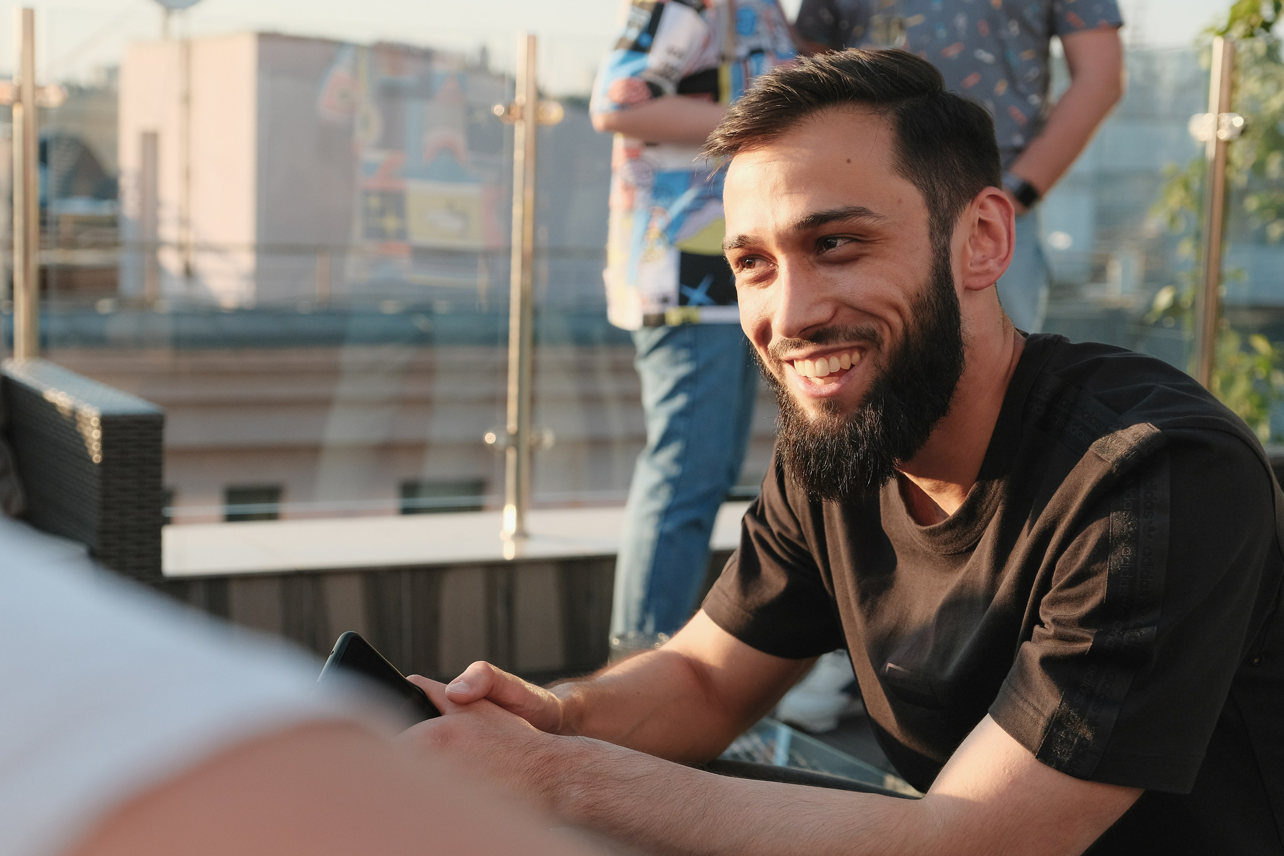 Мужчина с бородой улыбается и ведет беседу.