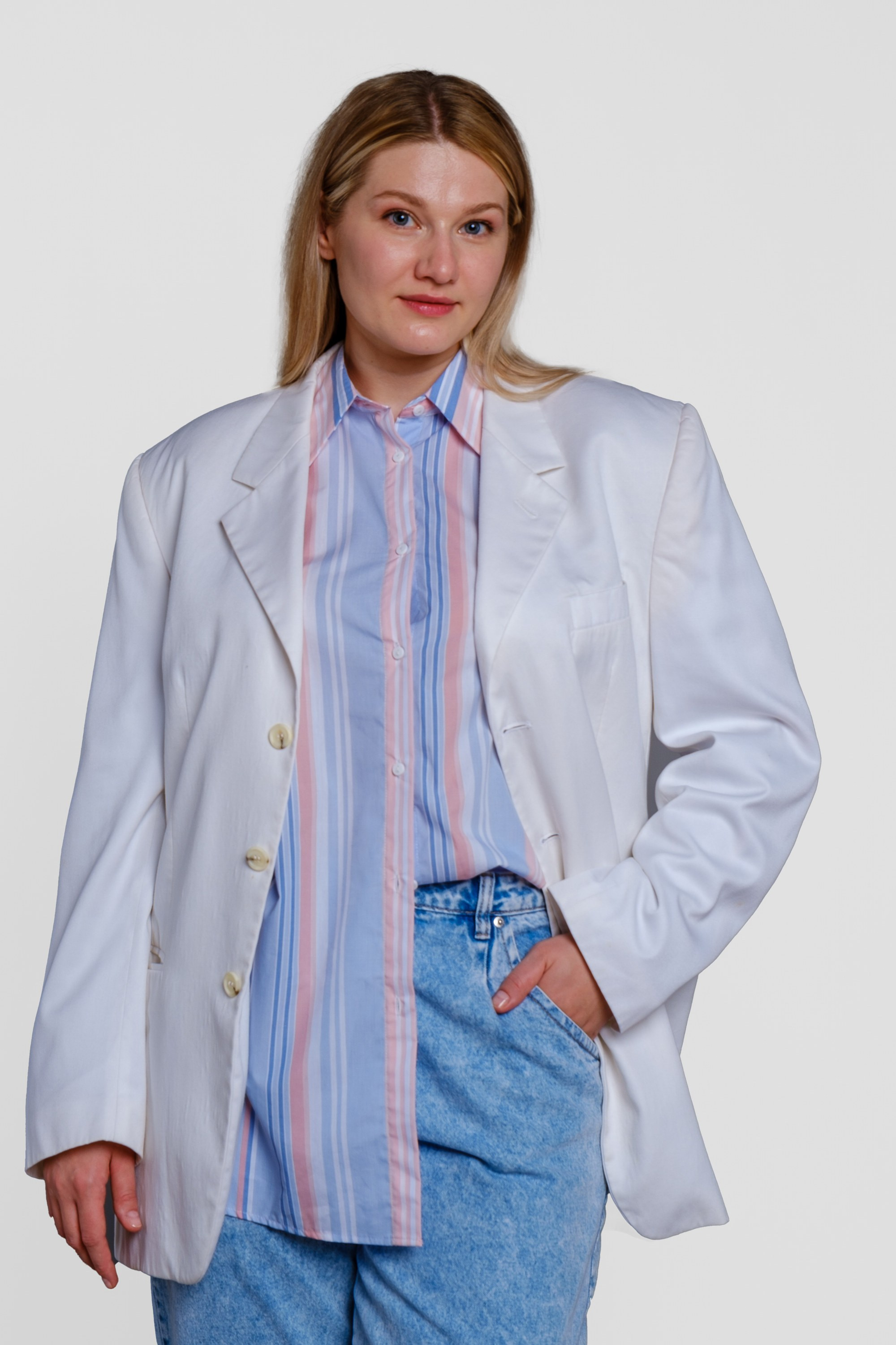 Девушка оверсайз в белом пиджаке и голубых брюках. Фото для маркетплейсов