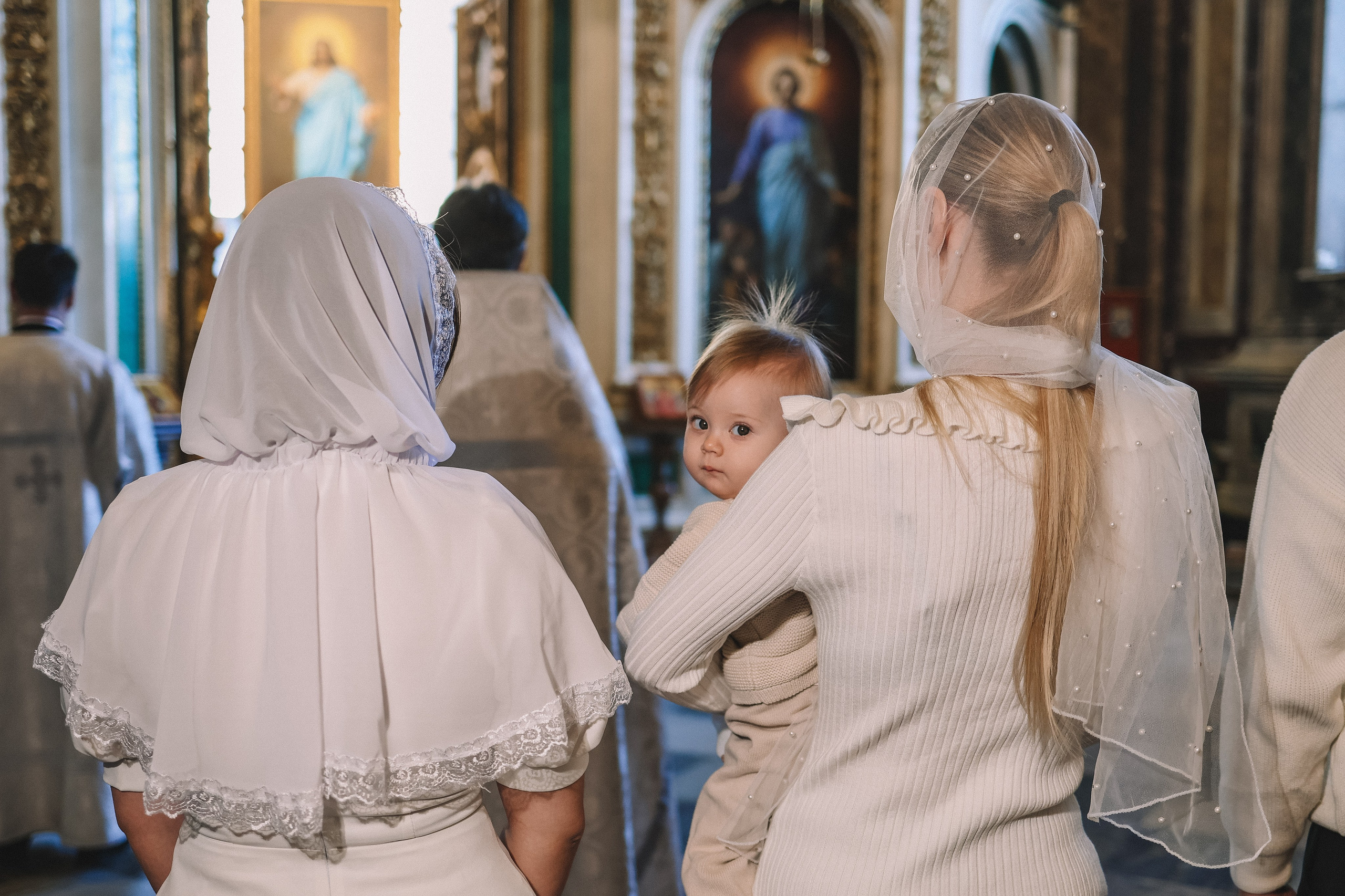 Семья во время таинства крещения ребенка в соборе СПб