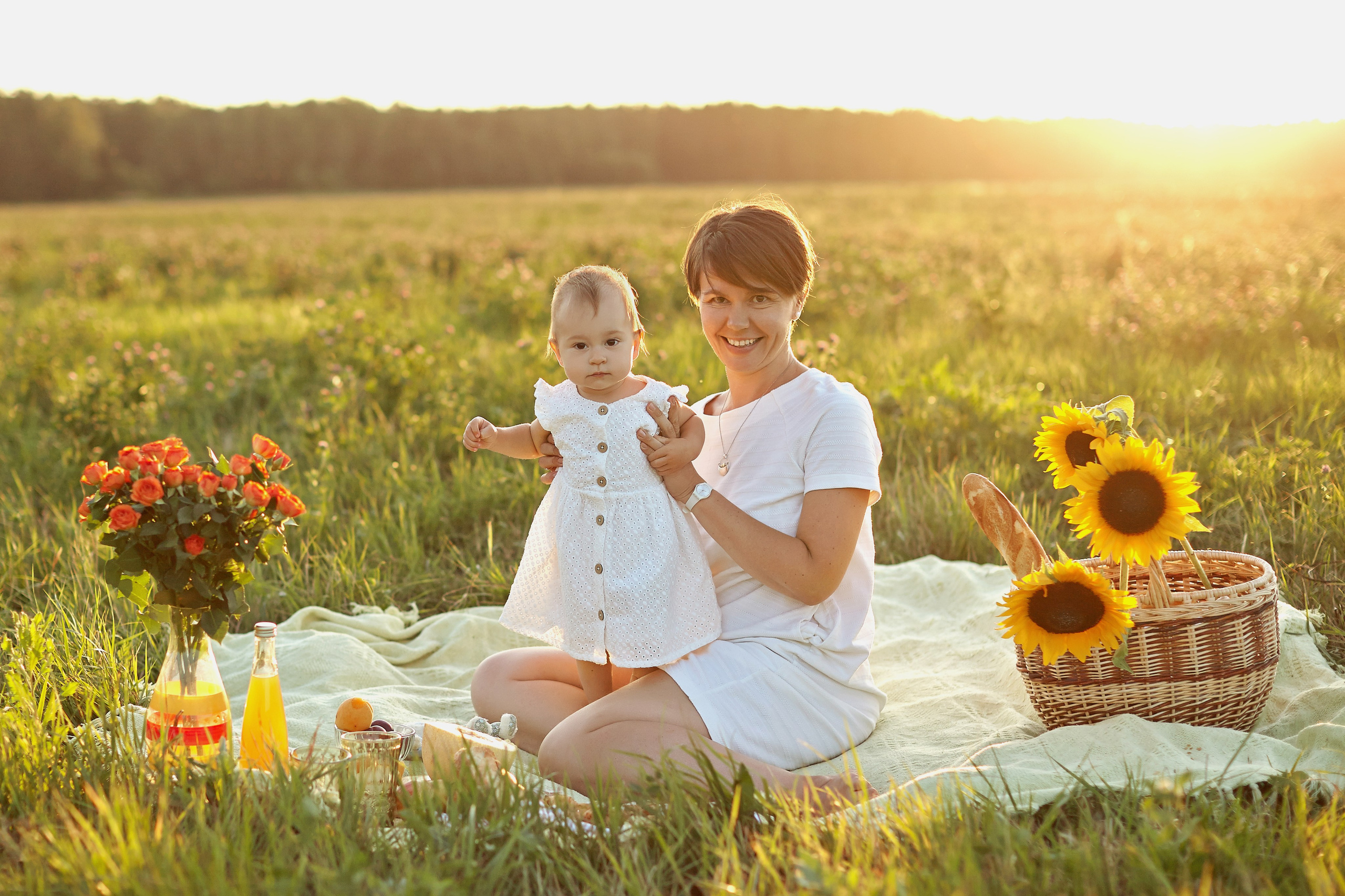 пикник мамы с годовалой дочкой и с подсолнухами в корзинке