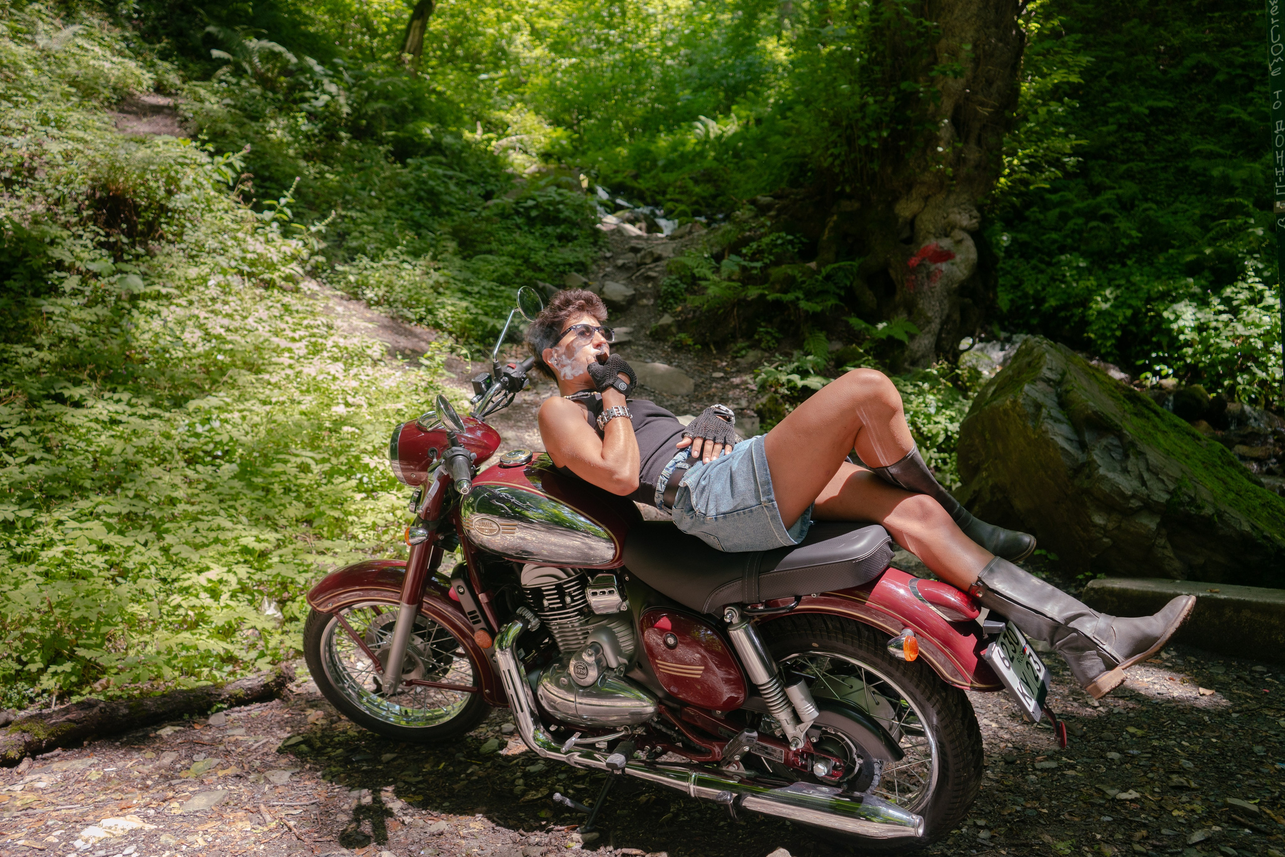 девушка лежит на мотоцикле у горного ручья