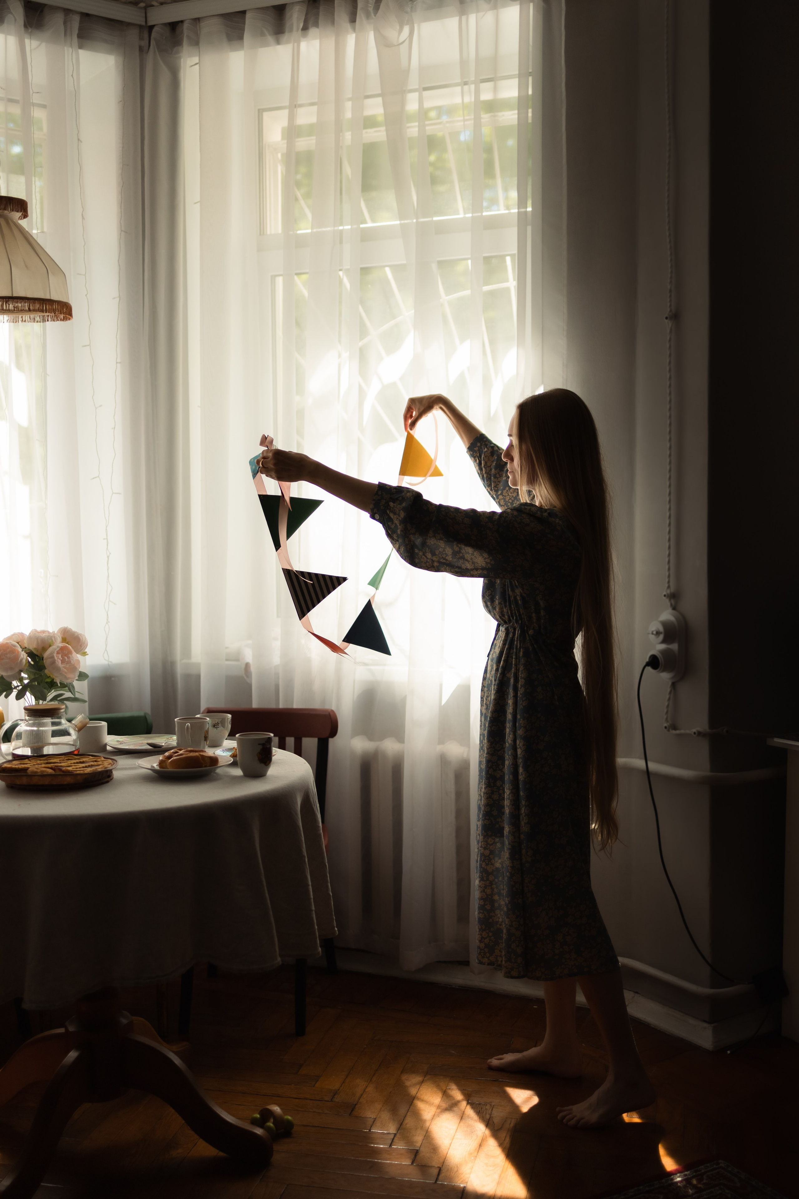 силуэт красивой мамы вешающей гирлянду