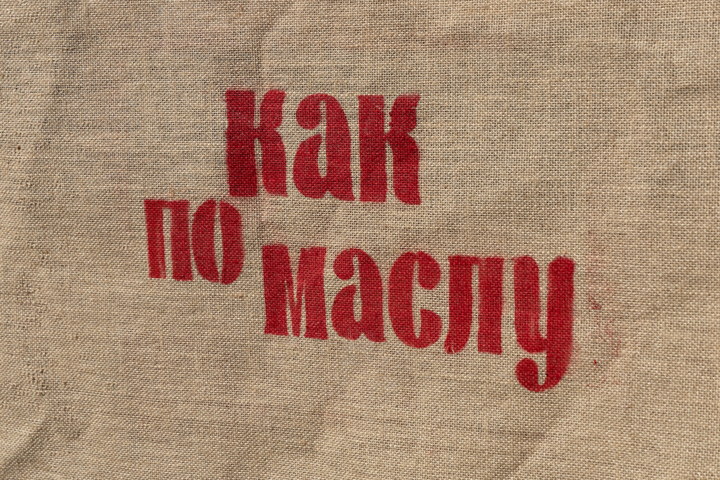 Красный принт названия фестиваля на мешковине.