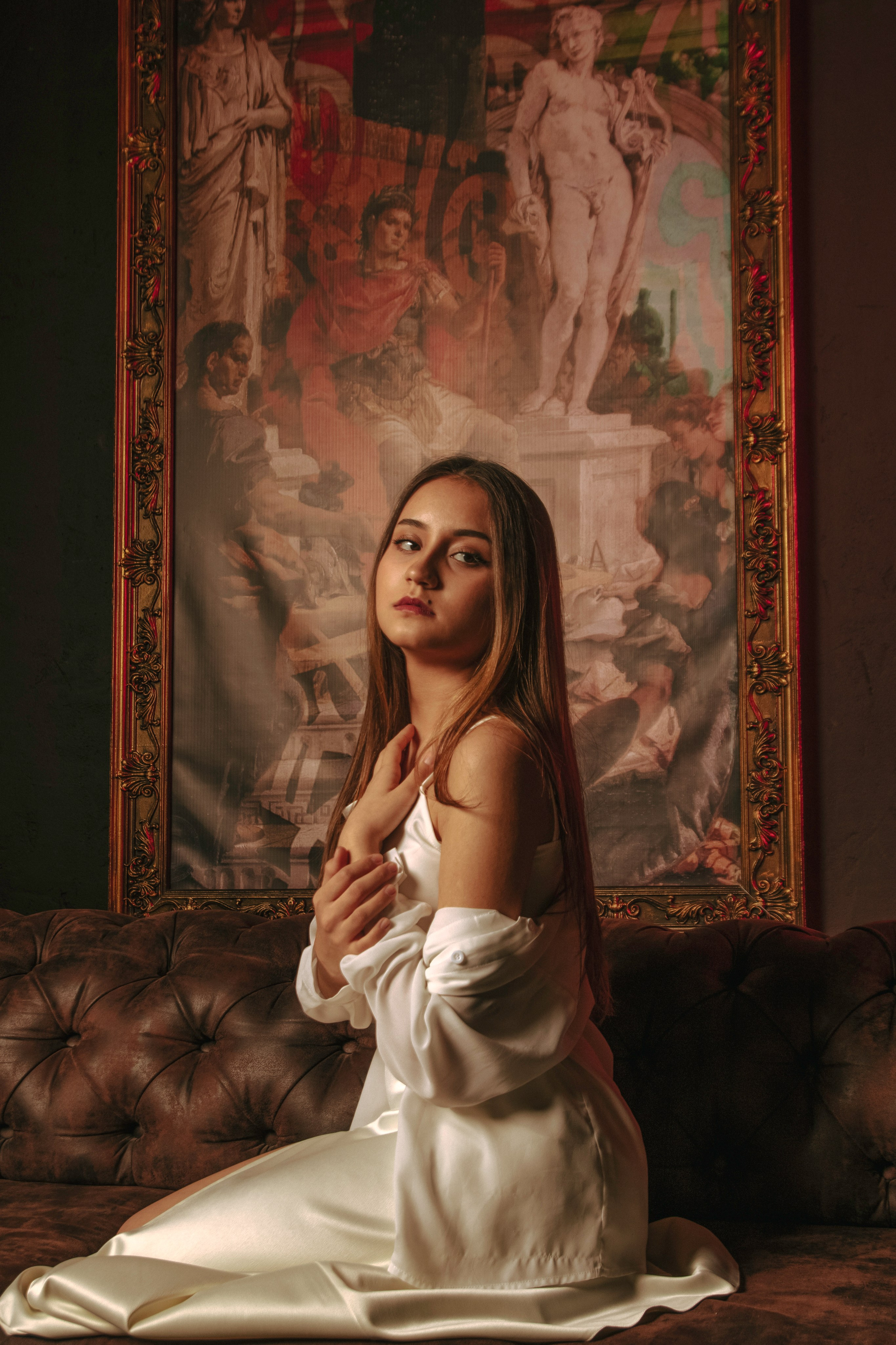 Красивая фотография девушки в белой одежде в стиле ренессанс на фоне картины 