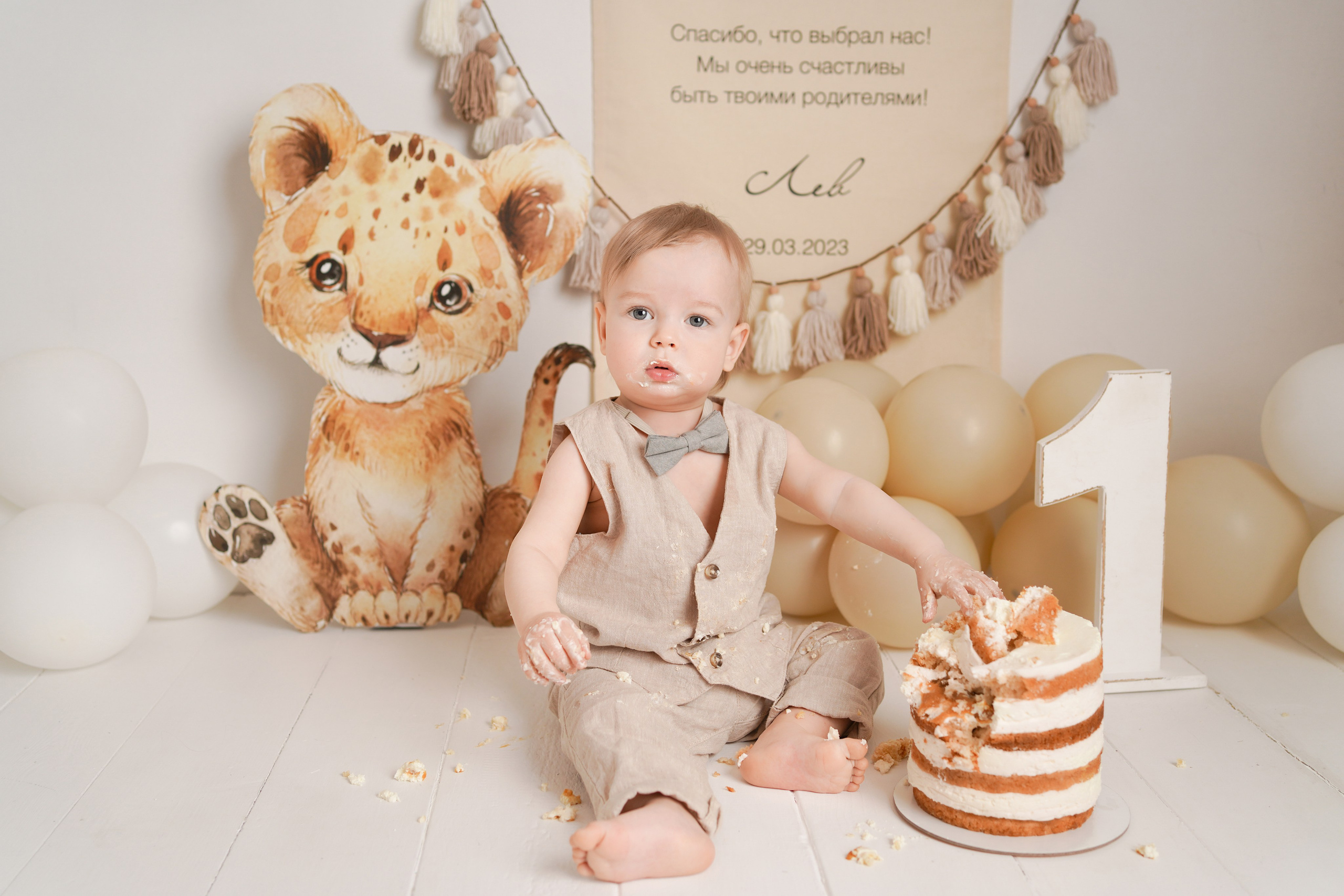 На фото малыш с тортиком. Малыша зовут Лев, поэтому рядом львёнок.