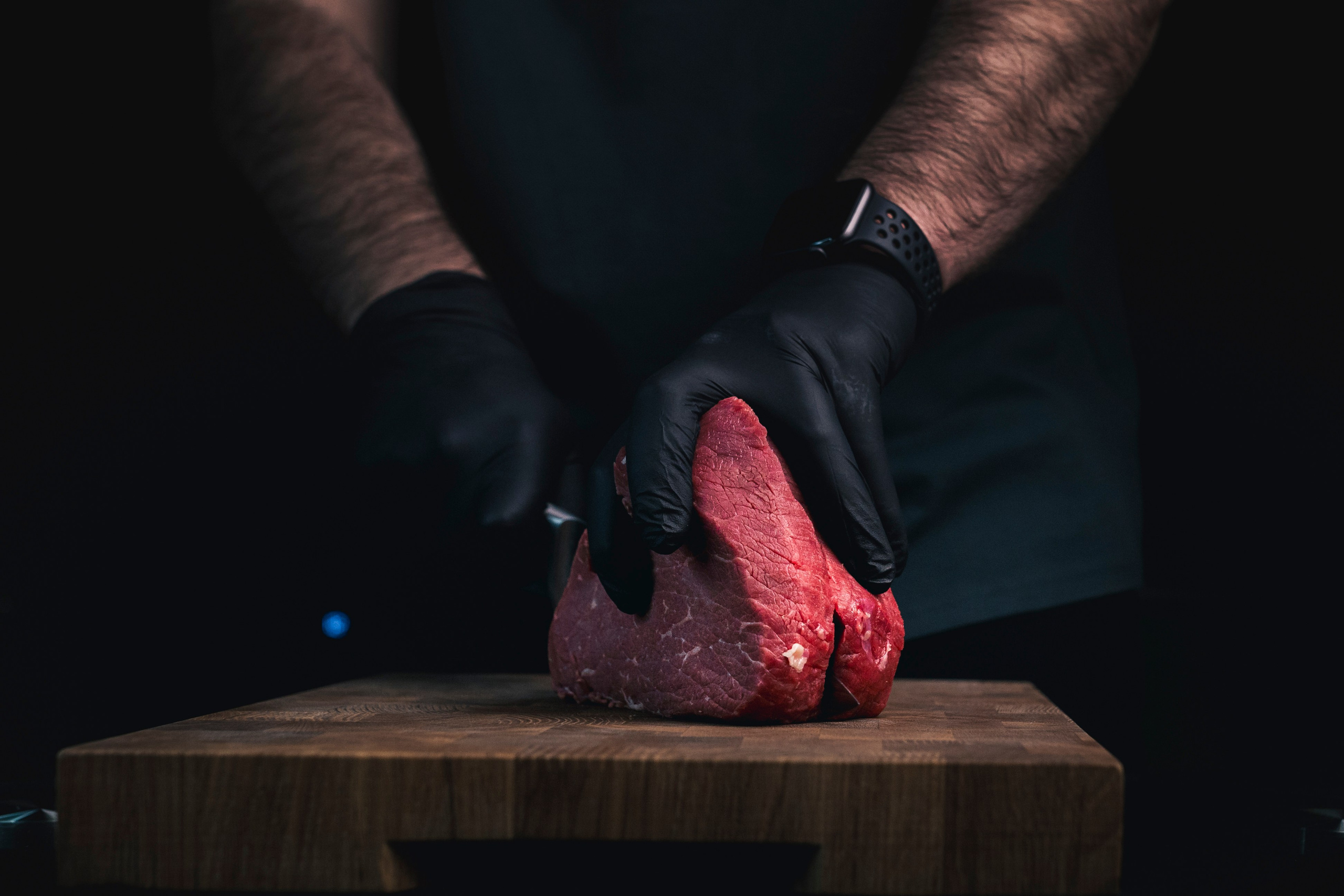 мужчина нарезает мясо 