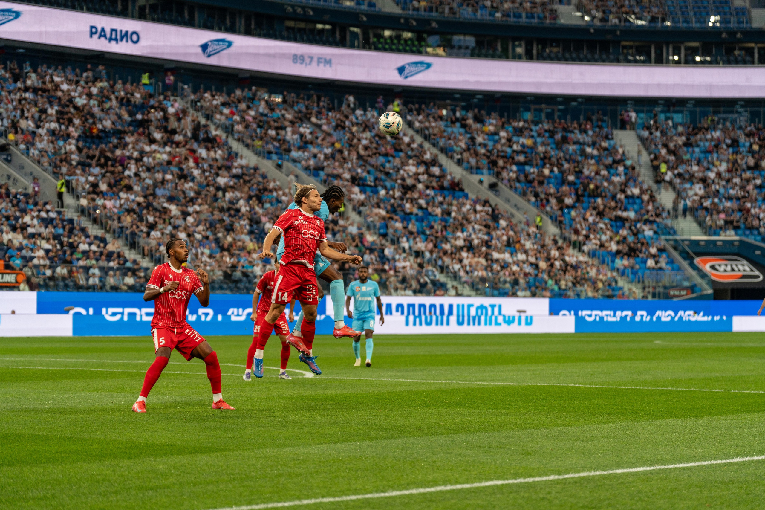 Футболисты «Зенита» и «Сьона» в борьбе за мяч в воздухе, репортажная спортивная съёмка, спортивный фотограф Санкт-Петербург.