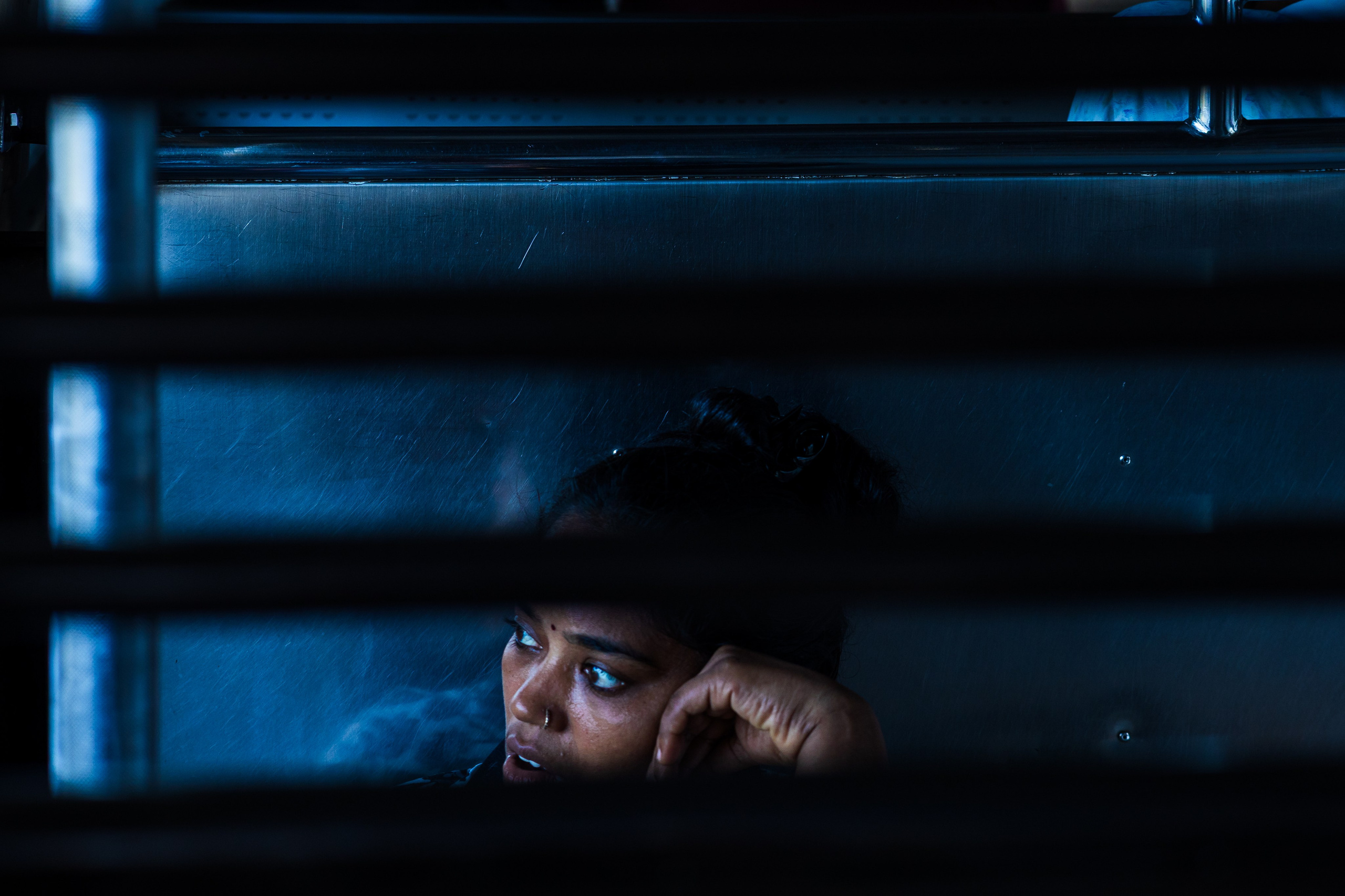 Мальчик выглядывает через горизонтальные жалюзи