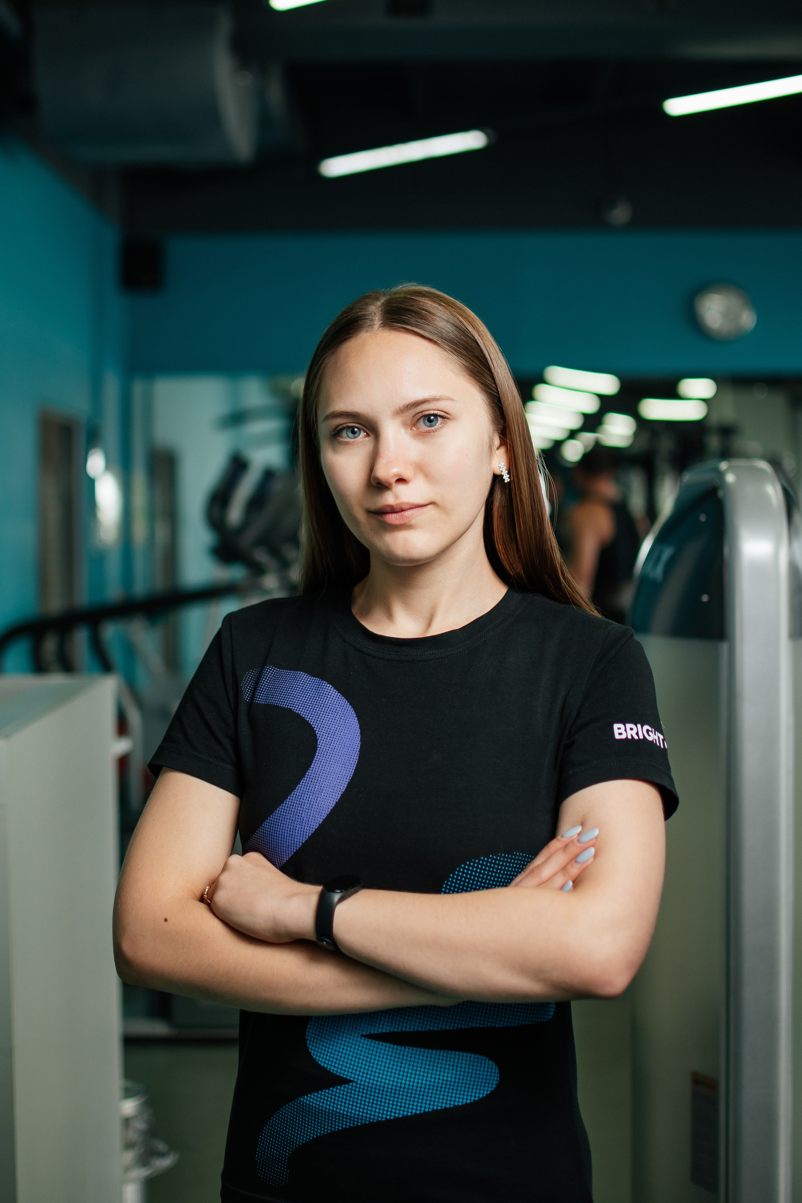 тренер фитнес-клуба на фоне зала фитнес-клуба