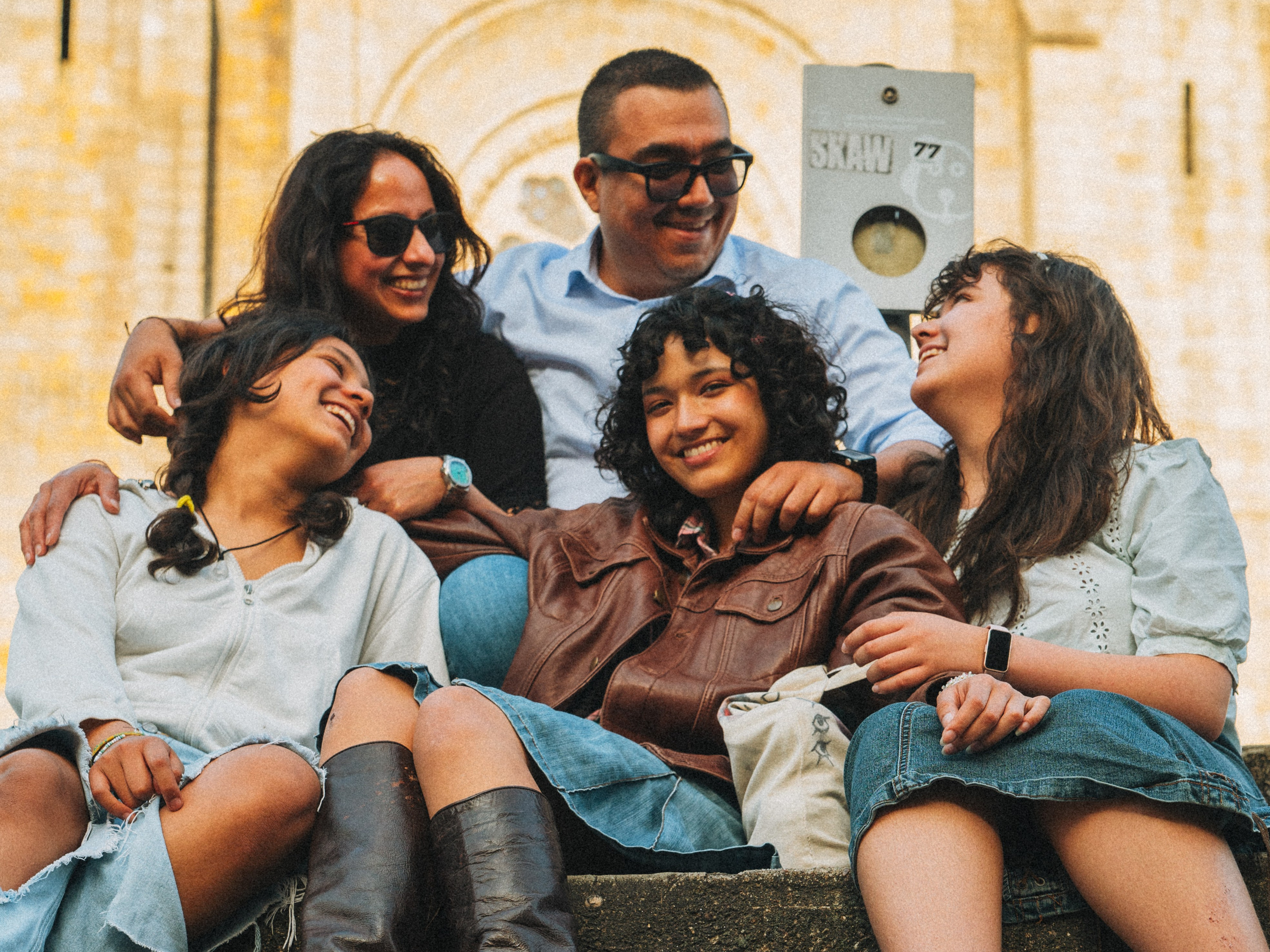 Группа людей семья влюбленные гуляет по живописной узкой улочке в Португалии, окружённой старыми домами и зеленью.