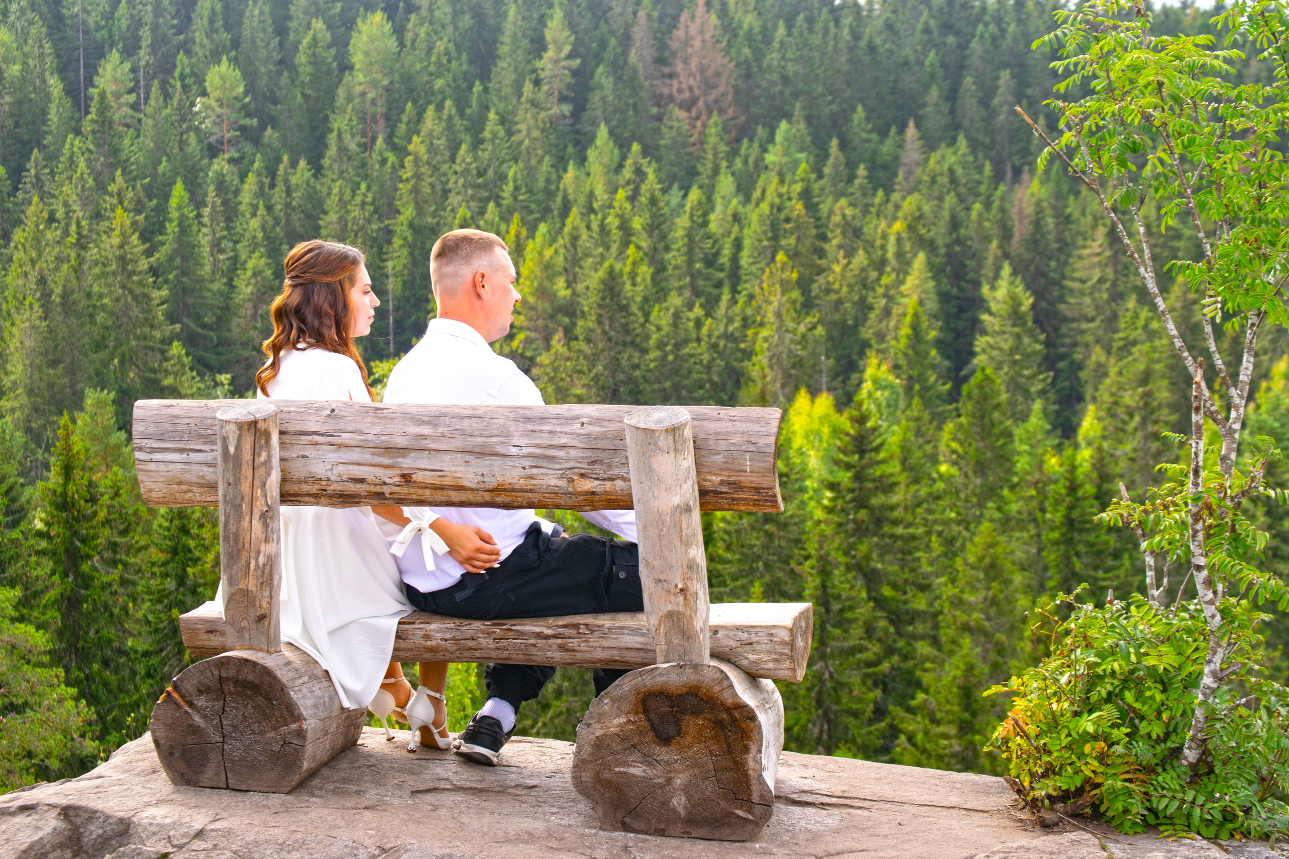 Свадебная фотосессия на горе Паасо Сортавала. Молодожены смотрят вдаль на лес.