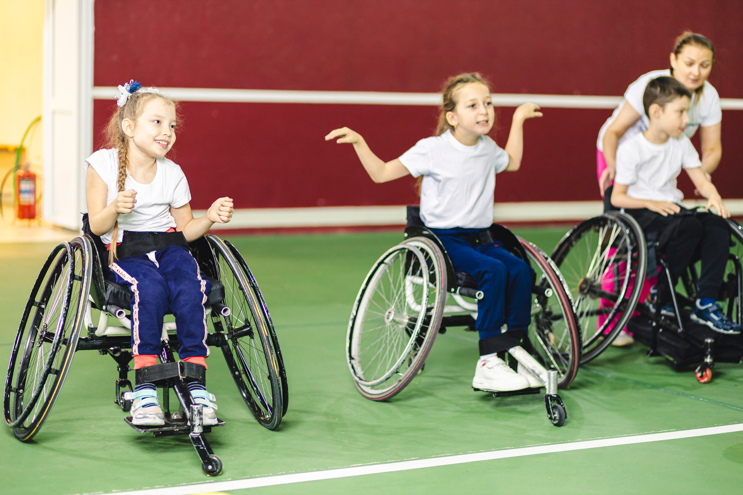дети разминаются перед игрой в теннис на колясках 