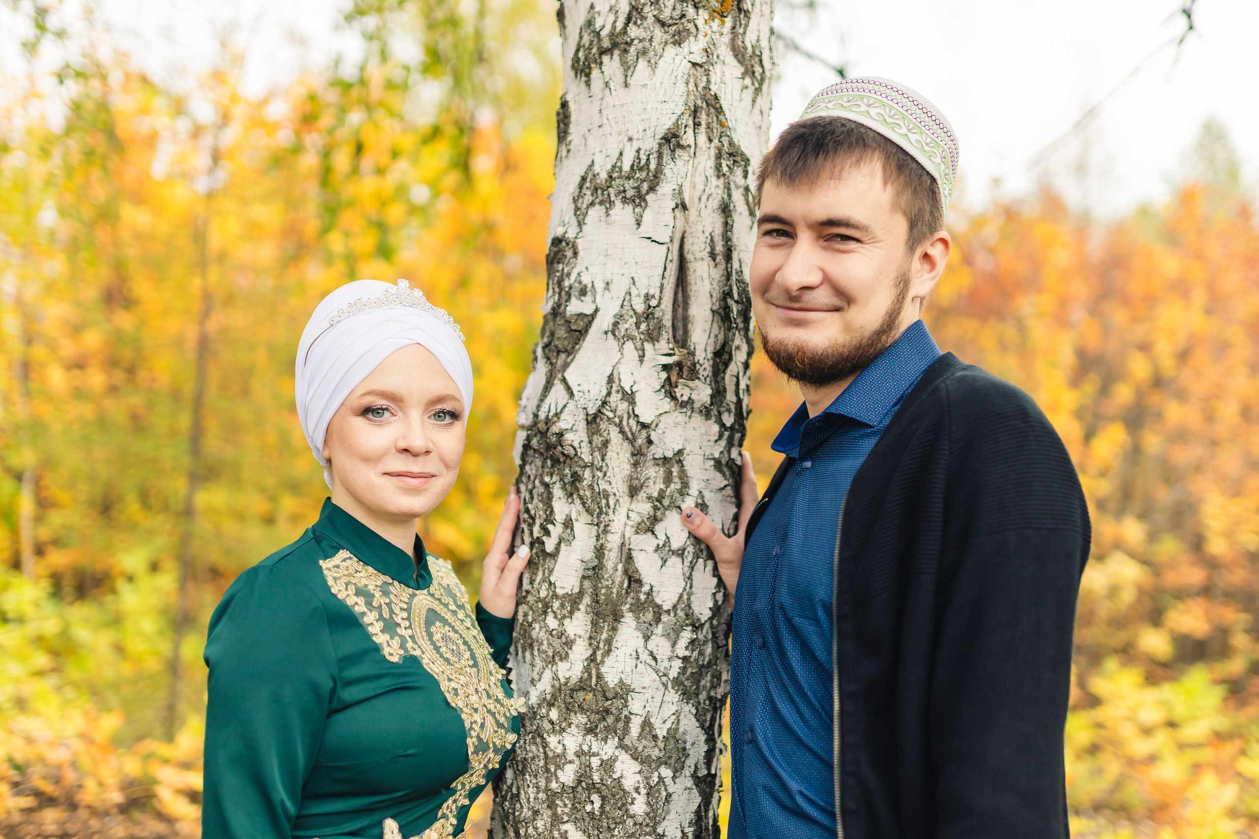 молодая пара стоят у берёзы 