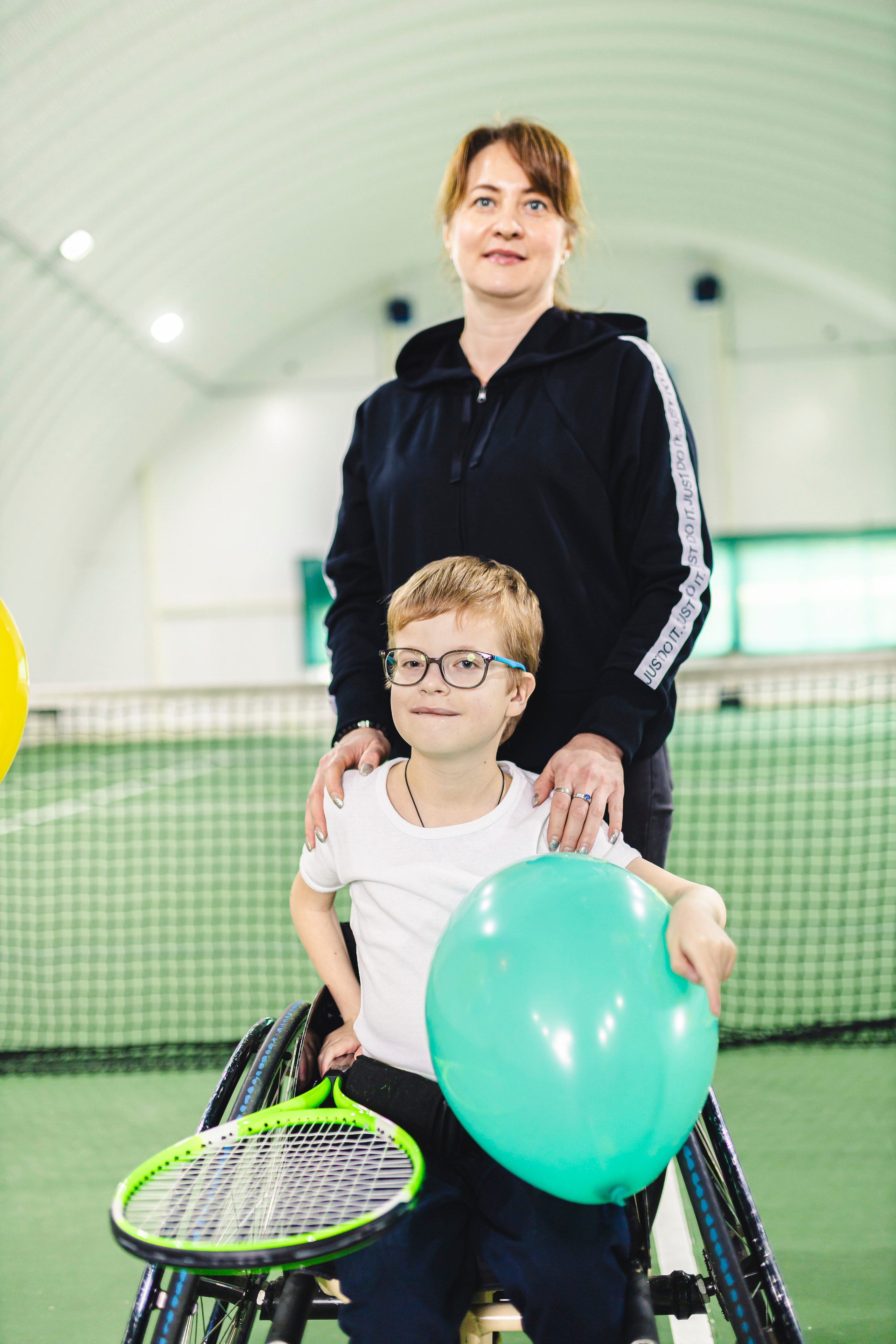 радостные дети с воздушными шариками на колясках