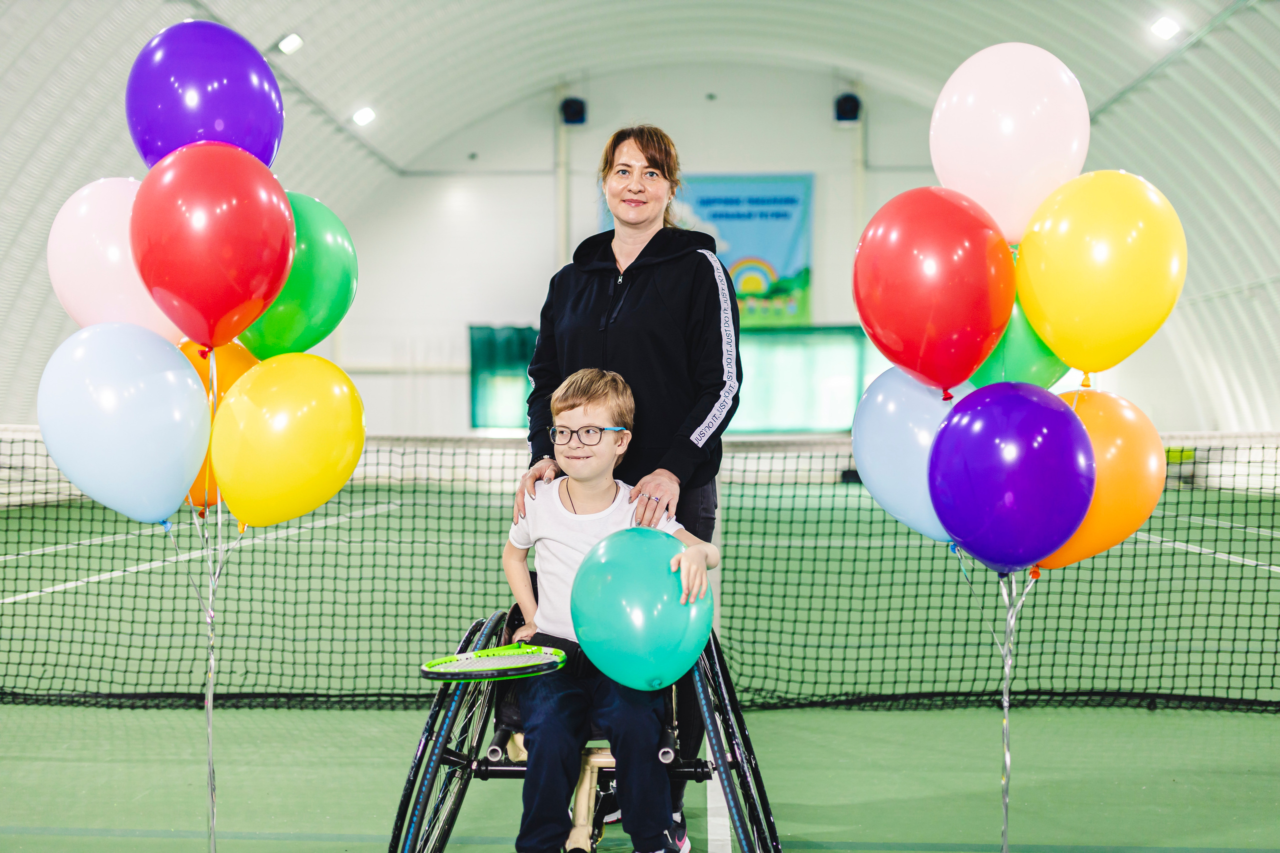 радостные дети с воздушными шариками на колясках