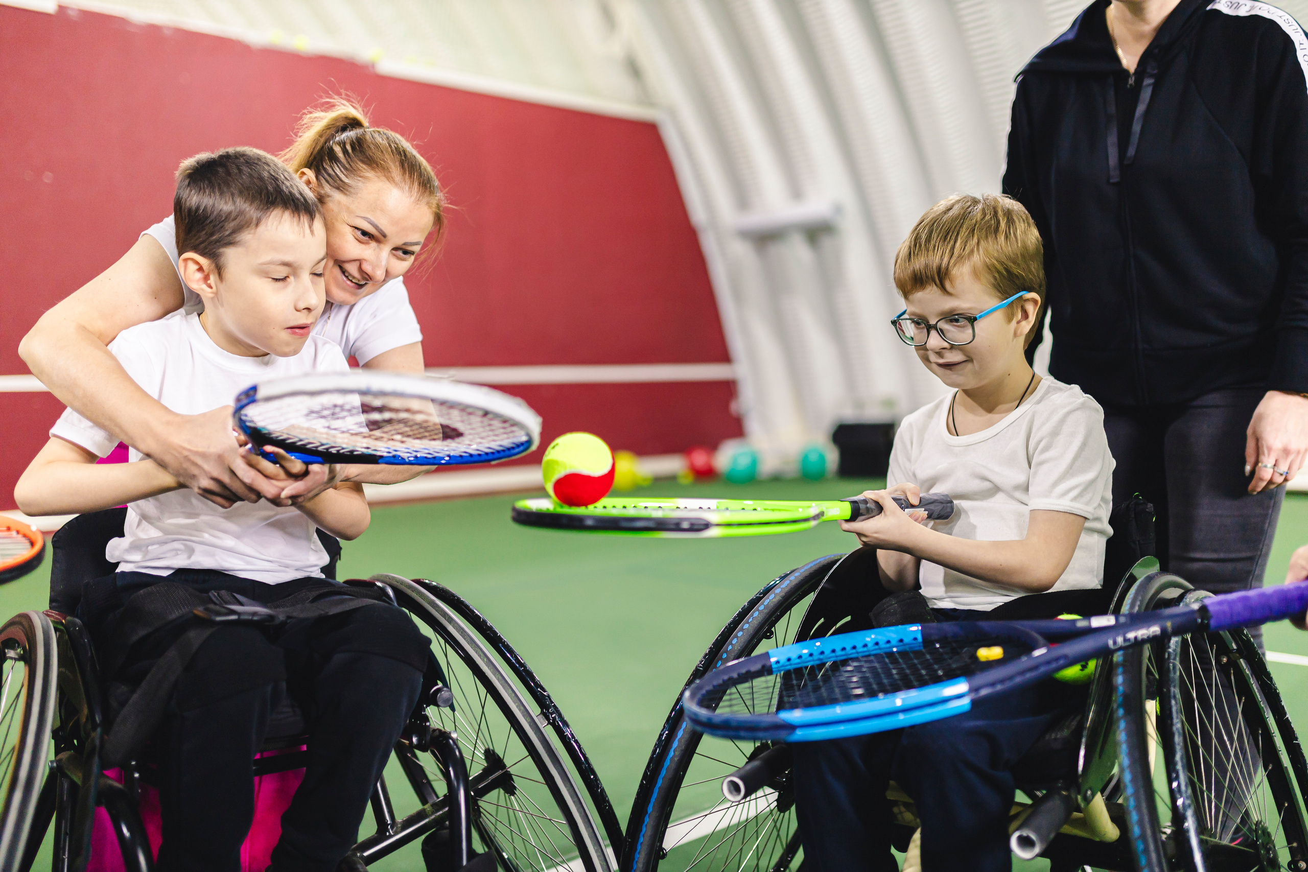 дети на колясках играют с теннисным мячиком 