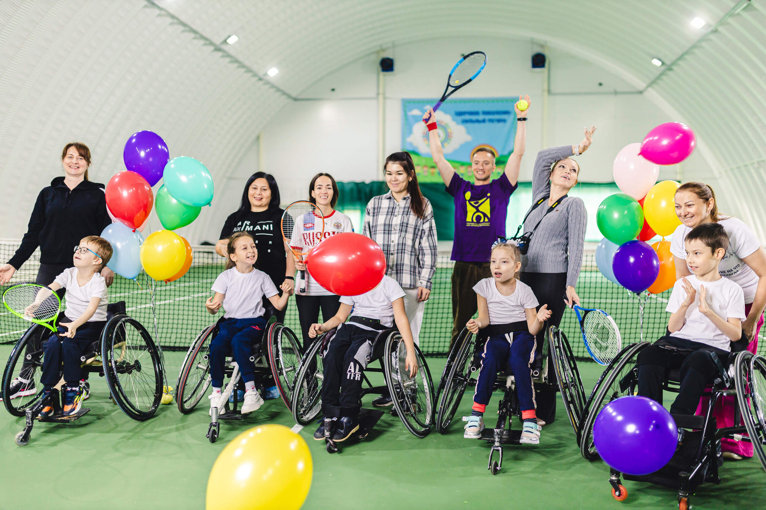 радостные дети с воздушными шариками на колясках