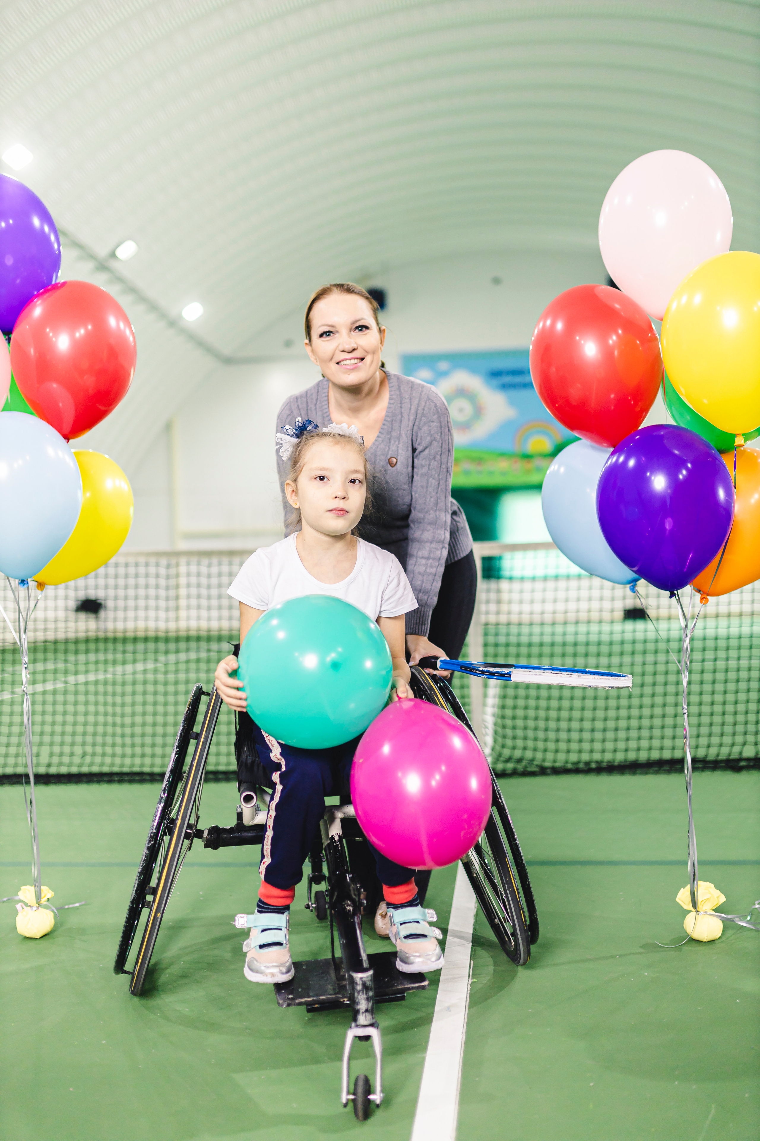 радостные дети с воздушными шариками на колясках