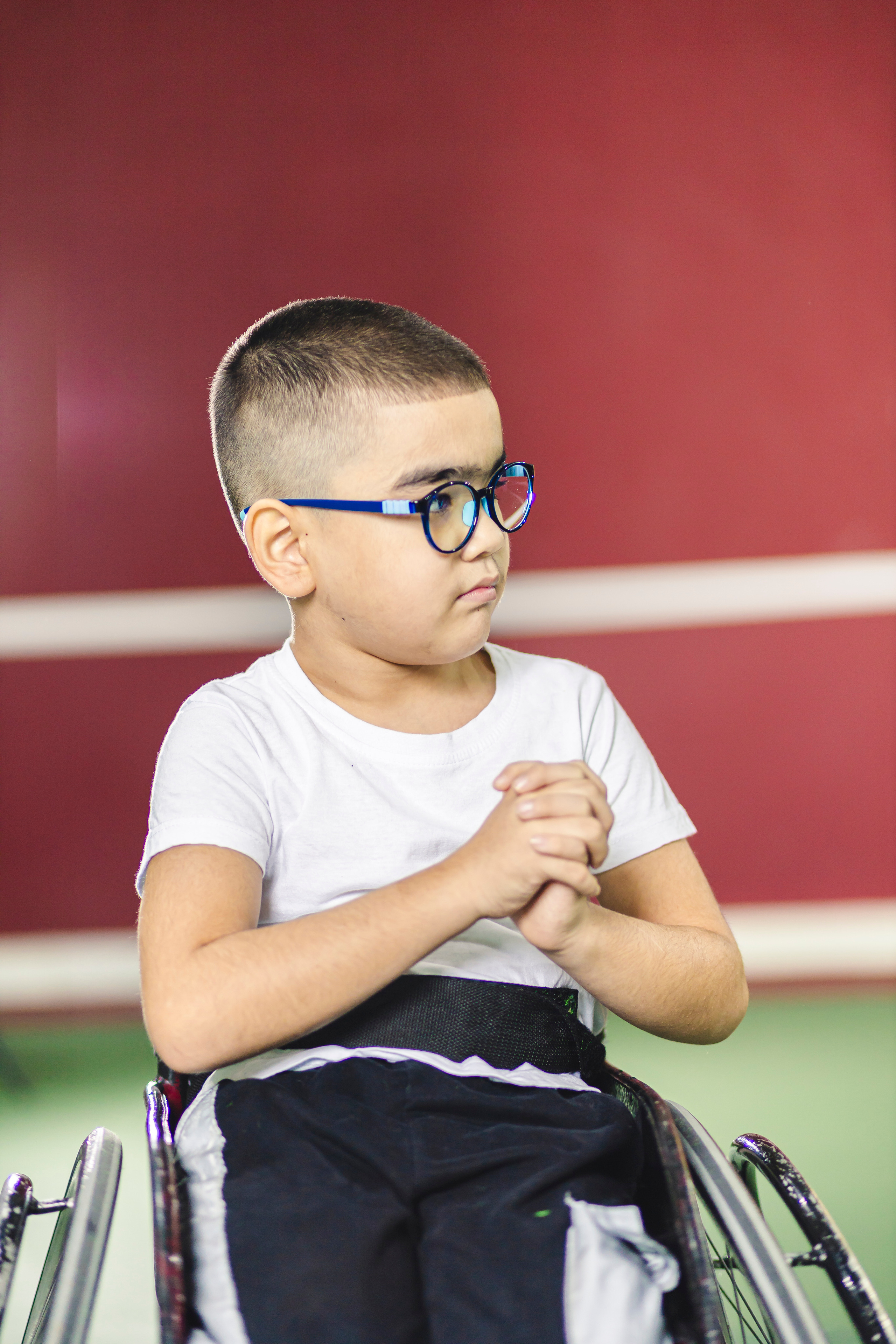 Мальчик в очках на коляске 