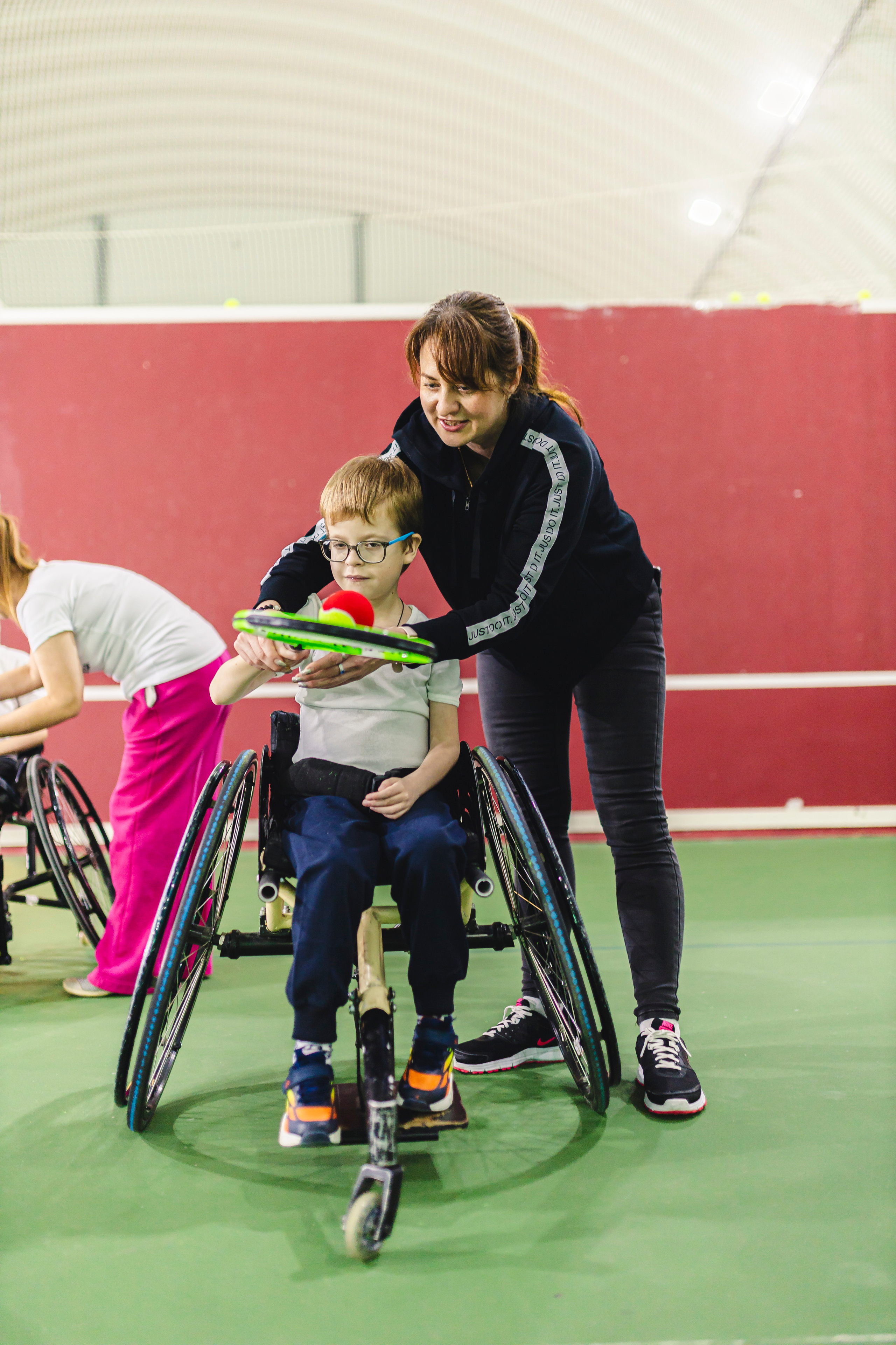 преподаватель по теннису учит детей 