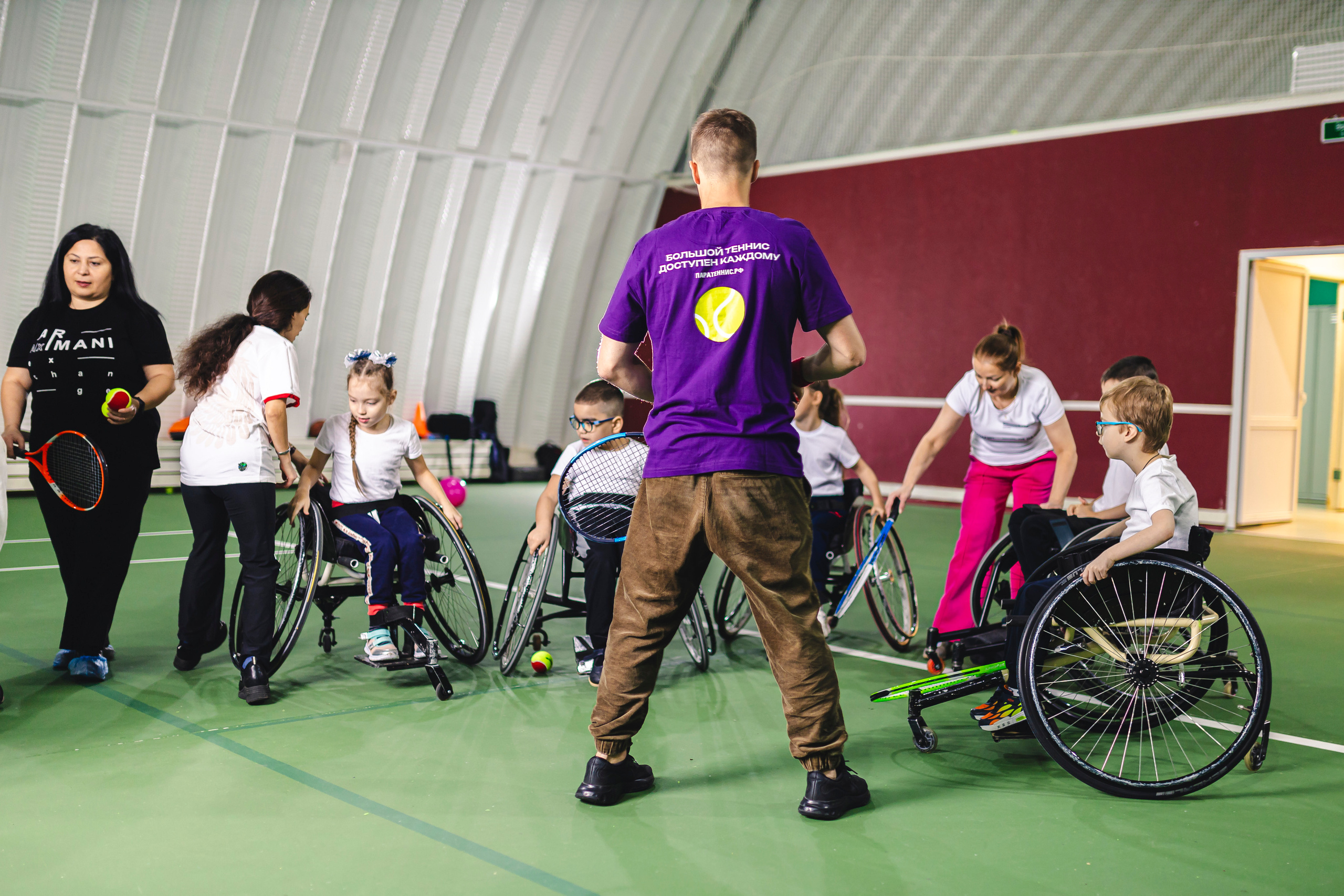 Тренер с детьми на тренировках по теннису 