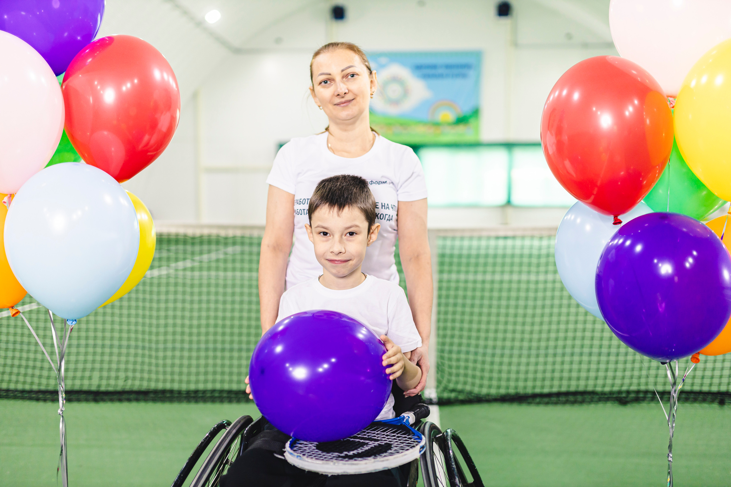 радостные дети с воздушными шариками на колясках