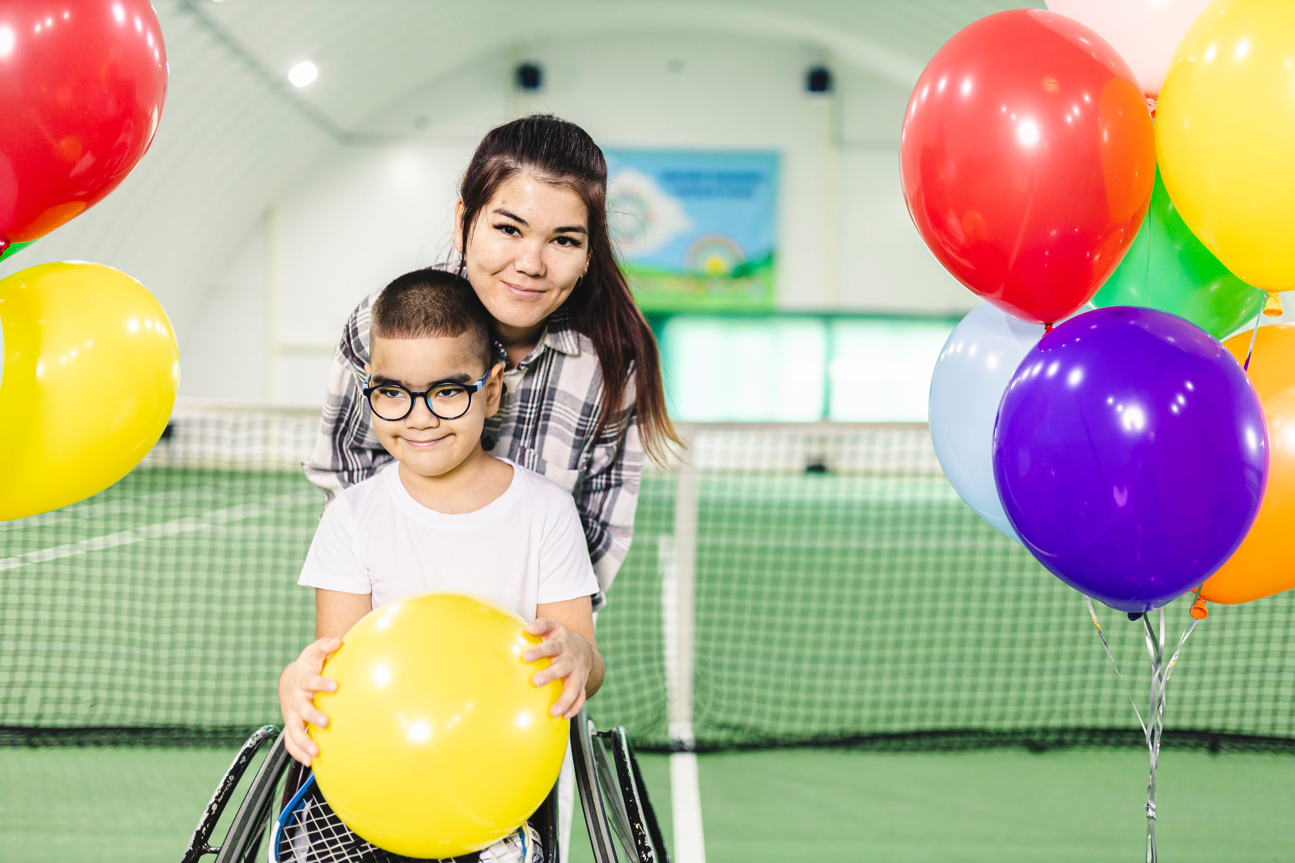 радостные дети с воздушными шариками на колясках