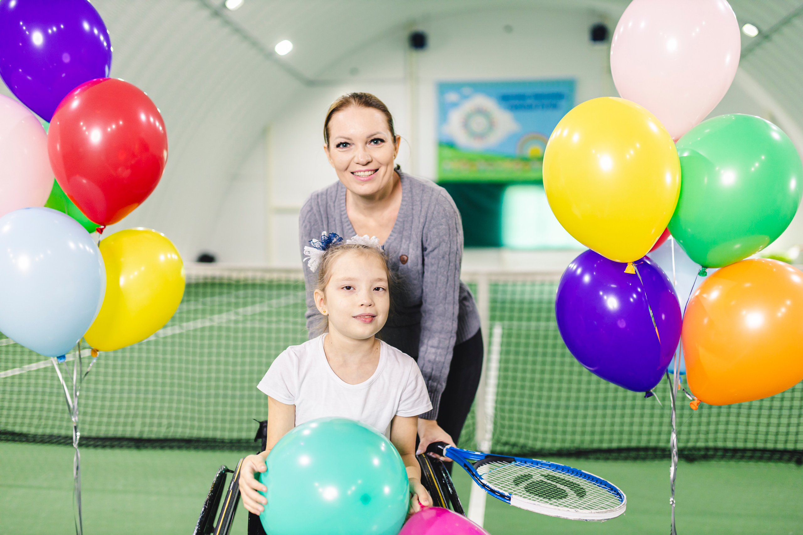 радостные дети с воздушными шариками на колясках