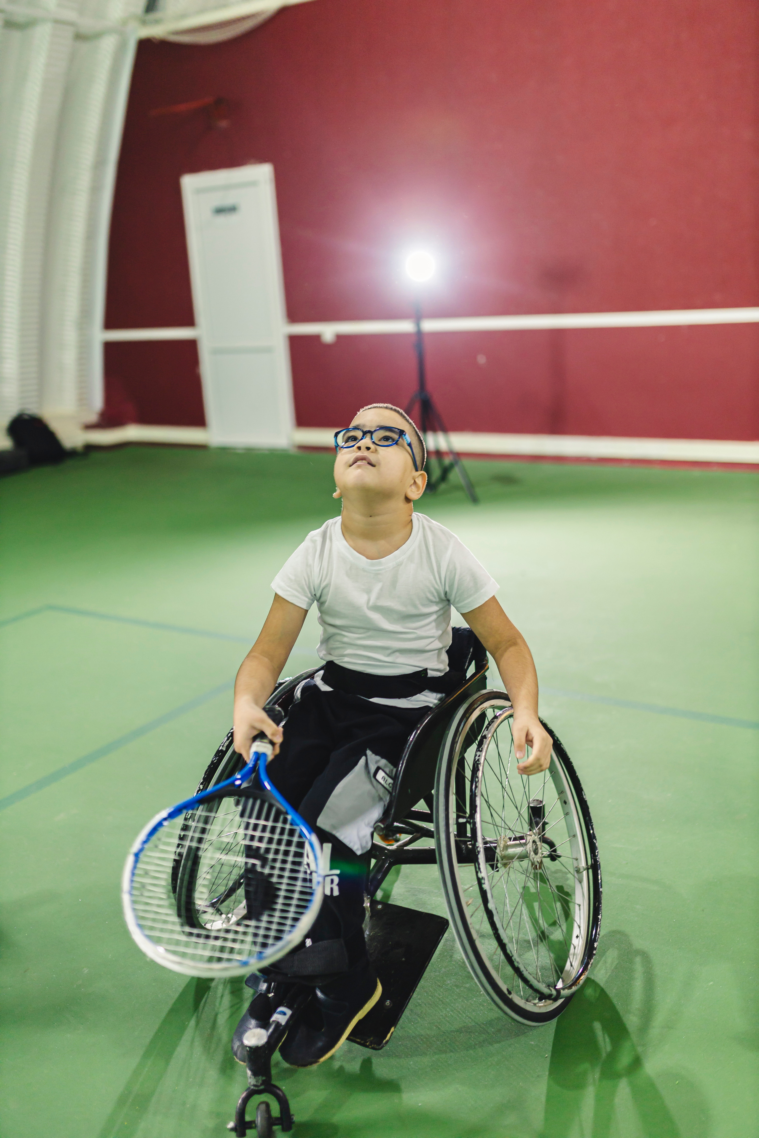 мальчик на коляске с теннисной ракеткой 