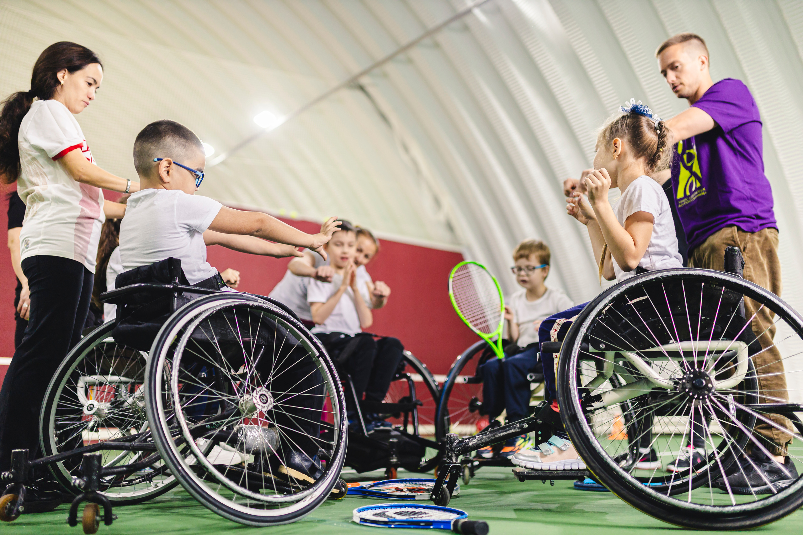 фото детей на колясках в спортивном зале, играющие в теннис 