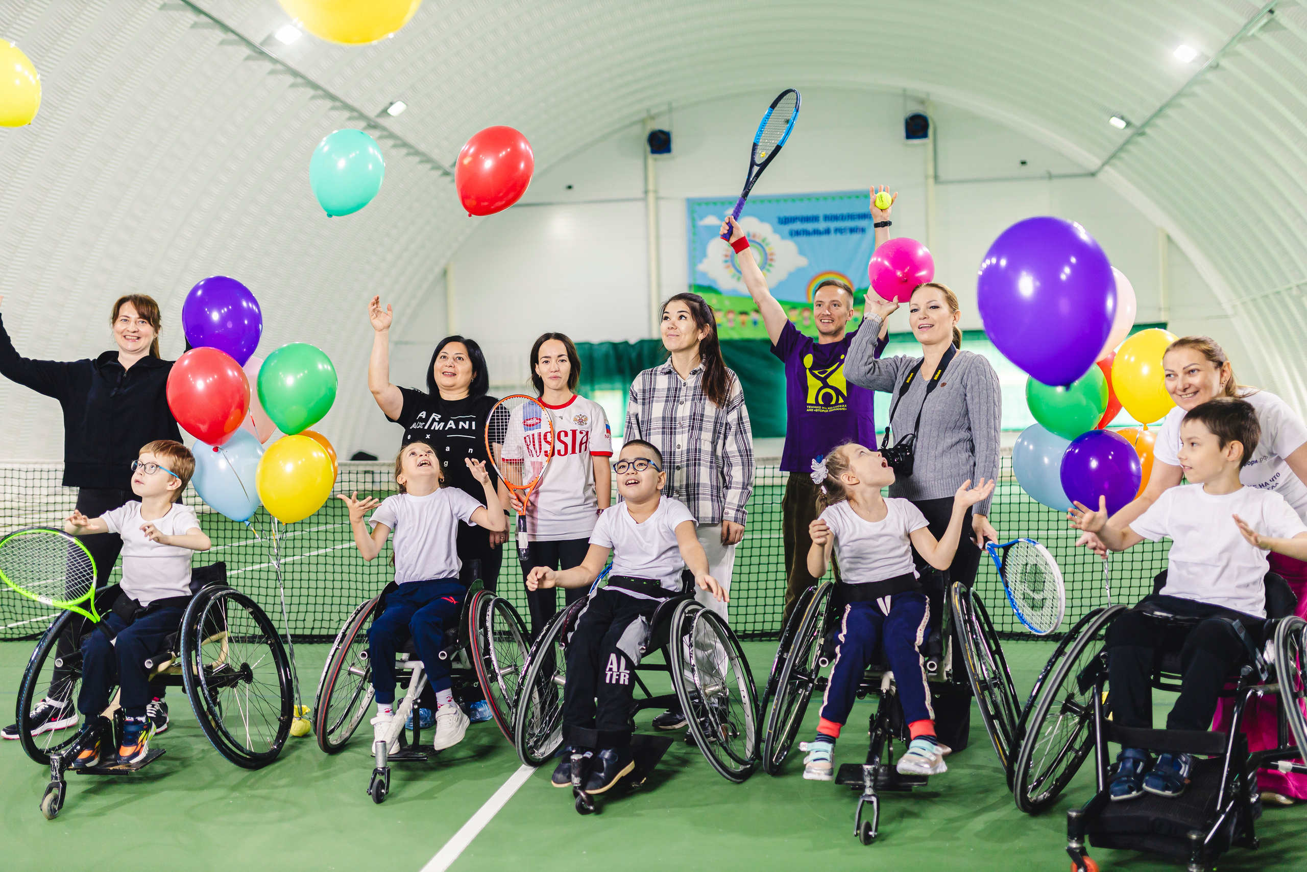 радостные дети с воздушными шариками на колясках