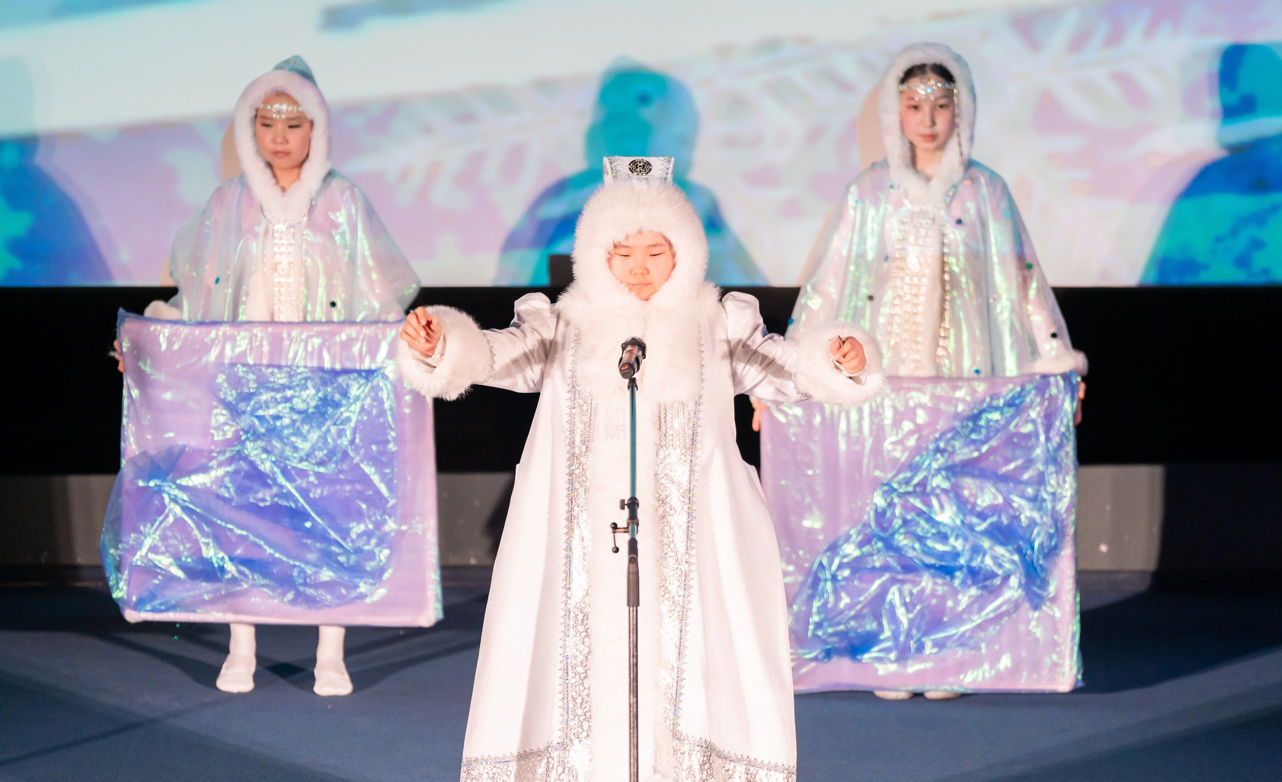 Выступление юных артистов в белых северных костюмах с реквизитом на XII Международном фольклорном фестивале «Сохраняем традиции» Санкт-Петербург 2026. Фото: Мальцев Евгений, evrednix.ru.