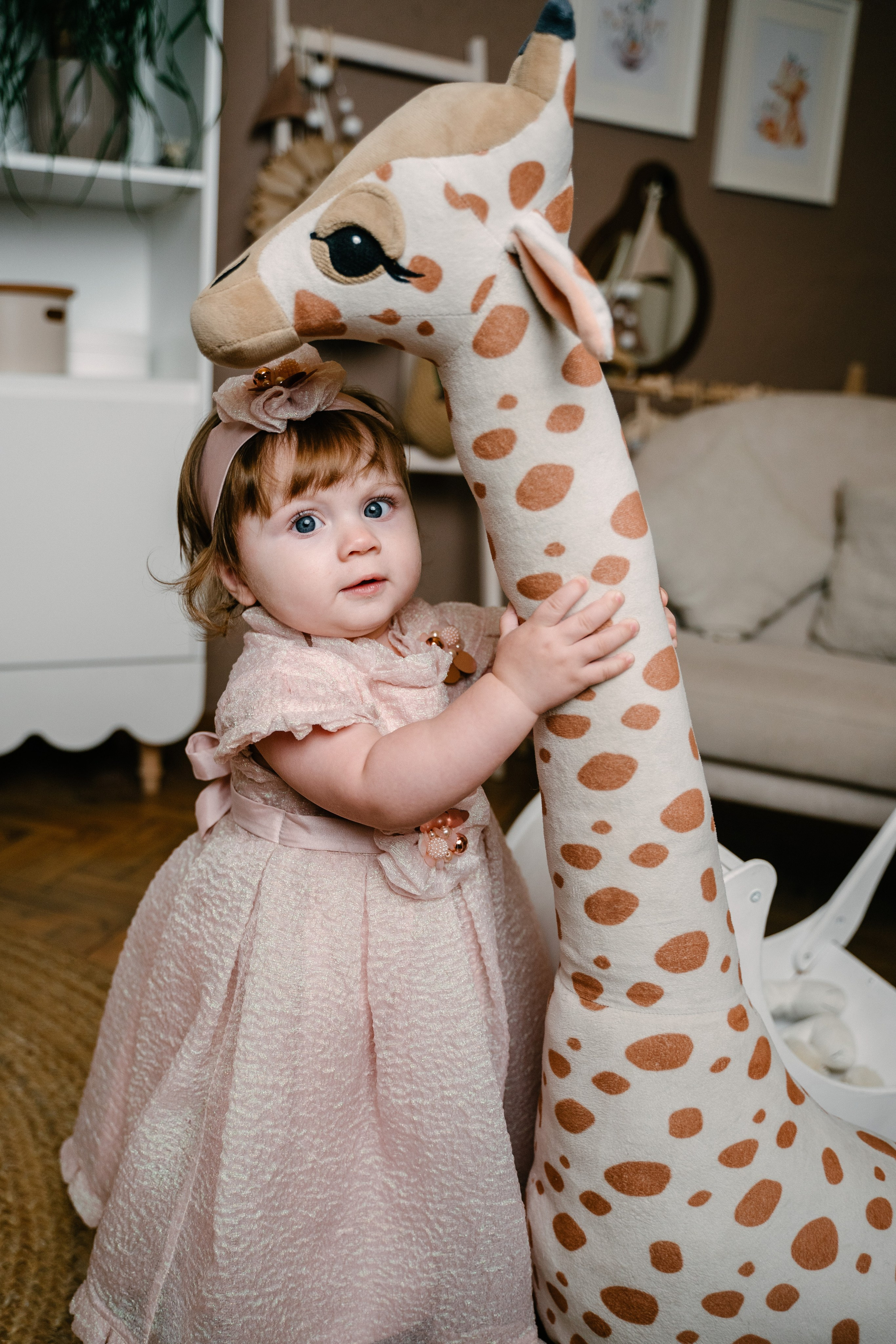 маленькая Девочка с выразительными глазами держит руками игрушку жирафа